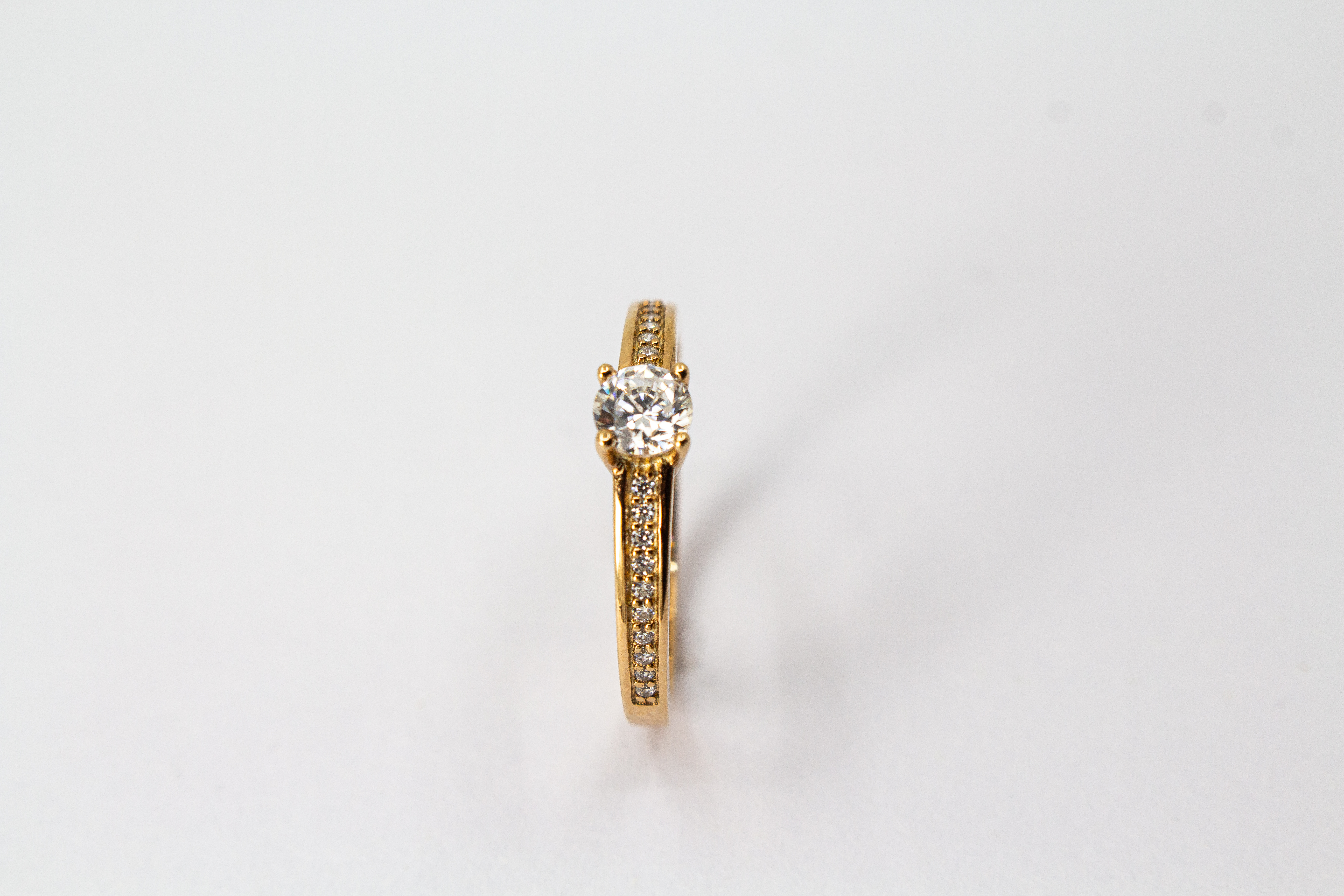 Eleganter Damenring aus rosévergoldetem 925 Sterling Silber mit einem großen, rund facettierten Zirkonia-Hauptstein in einer klassischen Vier-Krappenfassung und einer mit kleinen Zirkoniasteinen im Pavé-Stil besetzten Ringschiene aus dem Online-Shop der G