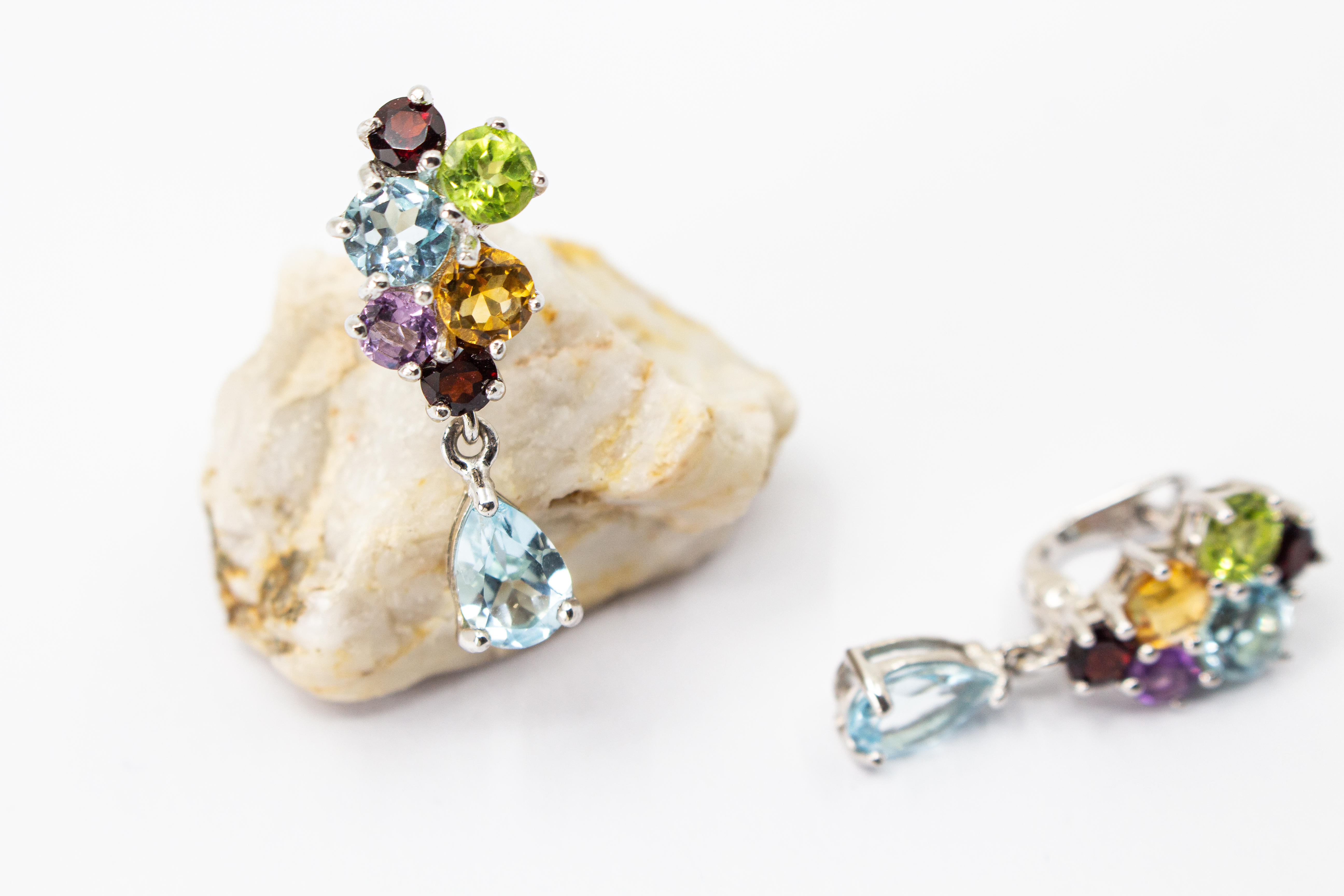 Elegante Multicolor-Edelstein-Ohrhänger aus rhodiniertem 925 Silber von der Goldschmiede Regina Kraus. Die detailreichen Ohrringe zeigen ein farbenfrohes Cluster aus rund facettierten Steinen wie Amethyst, Peridot, Citrin und Granat, gefolgt von einem bew