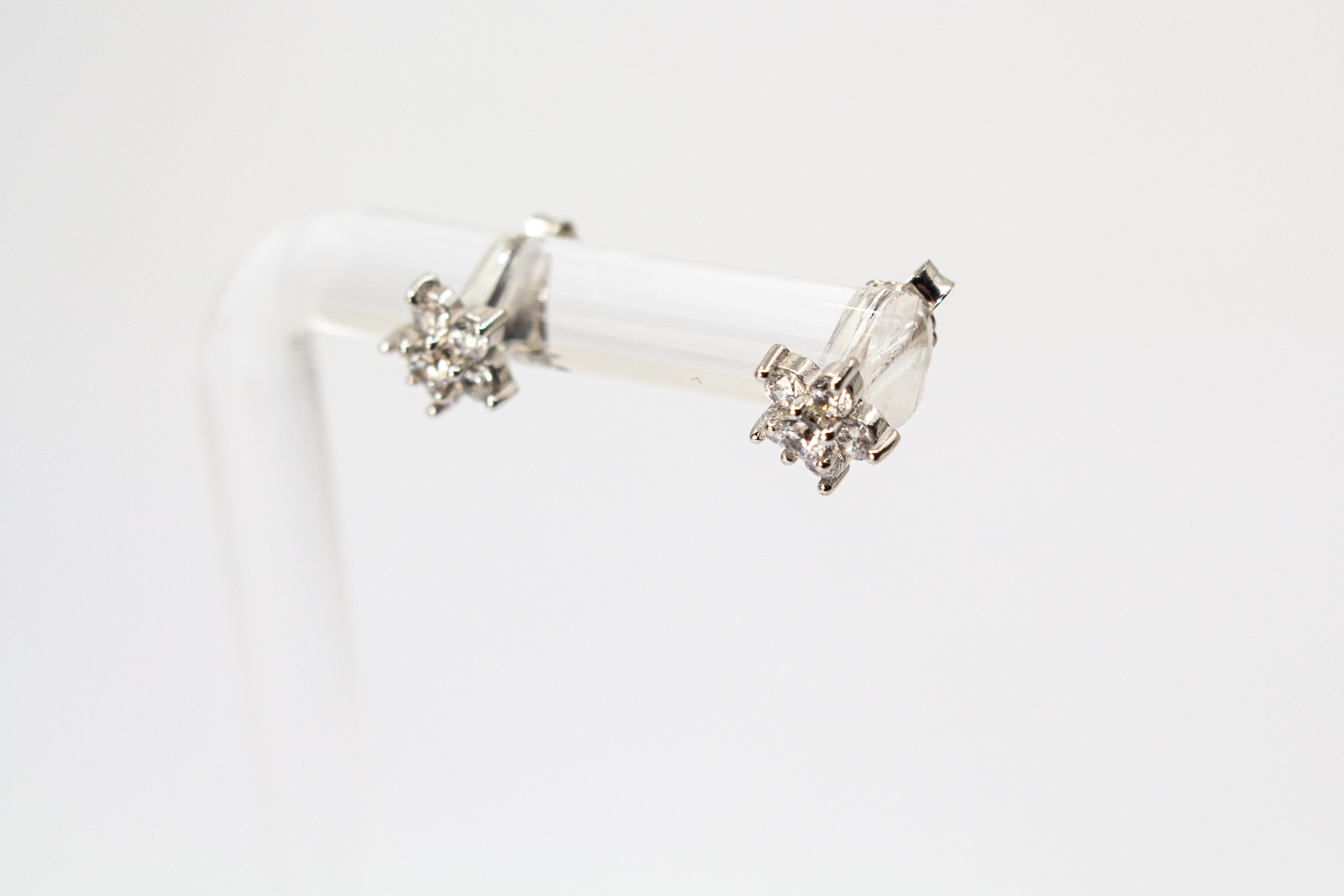 Filigrane Blumen-Ohrstecker aus rhodiniertem 925er Silber in Form einer kleinen Blüte mit funkelndem Zirkonia-Besatz im Onlineshop von Goldschmiede Regina Kraus.