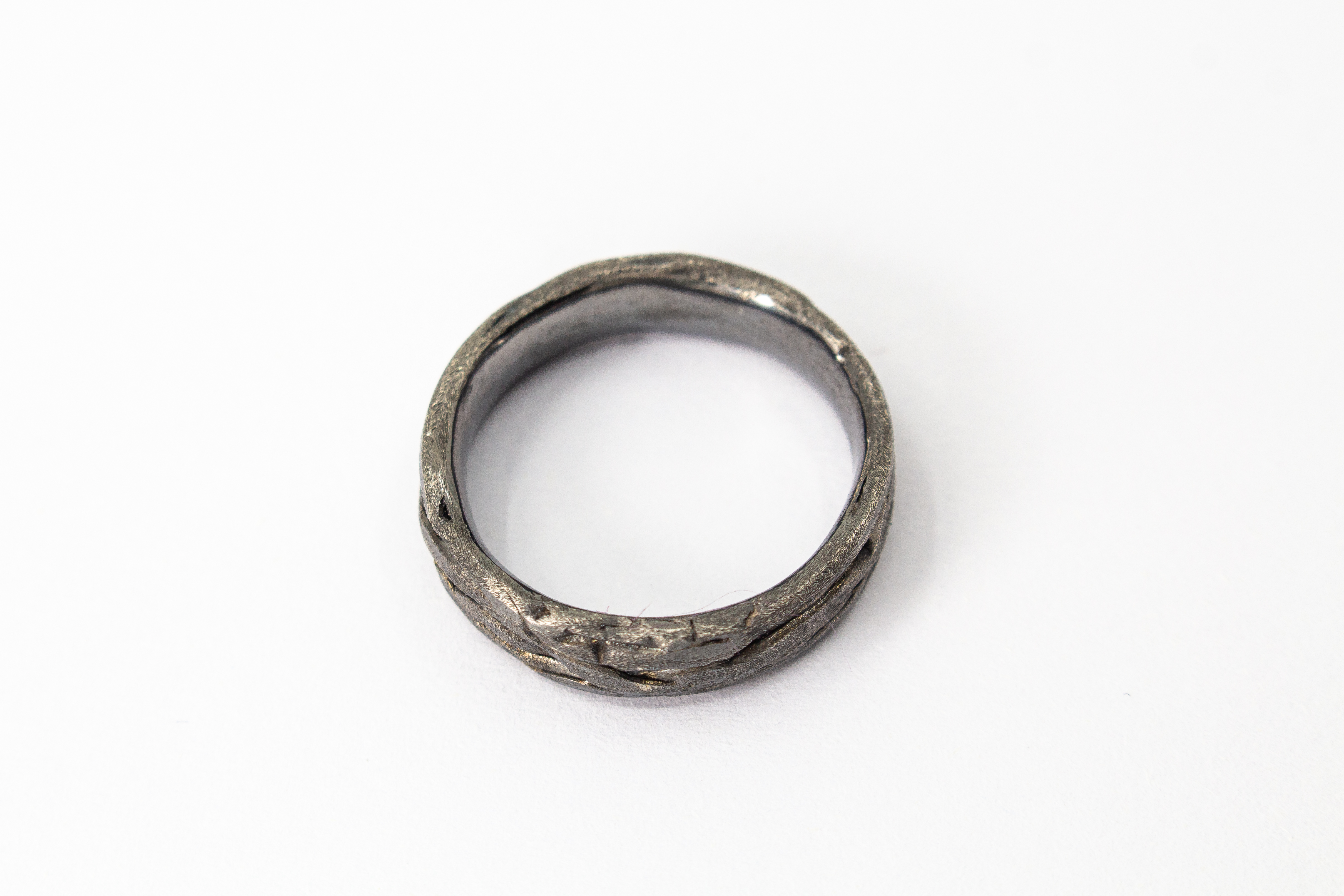 Markanter, strukturierter Bandring aus dunkel geschwärztem und oxidiertem 925 Sterlingsilber mit einer organisch geflochtenen Oberfläche im Ast- oder Rinden-Design aus dem Online-Shop der Goldschmiede Regina Kraus.