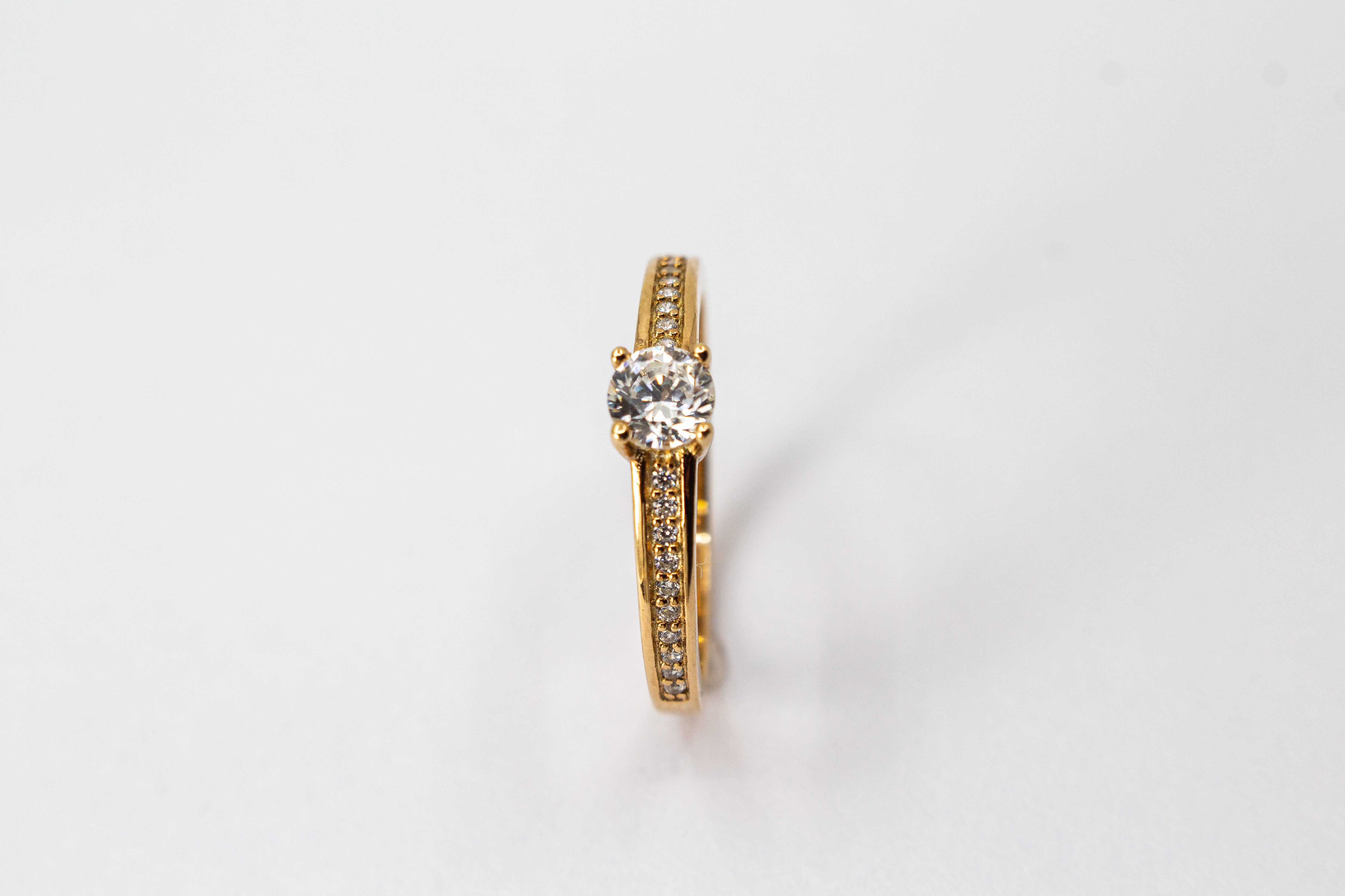 Eleganter Damenring aus rosévergoldetem 925 Sterling Silber mit einem großen, rund facettierten Zirkonia-Hauptstein in einer klassischen Vier-Krappenfassung und einer mit kleinen Zirkoniasteinen im Pavé-Stil besetzten Ringschiene aus dem Online-Shop der G