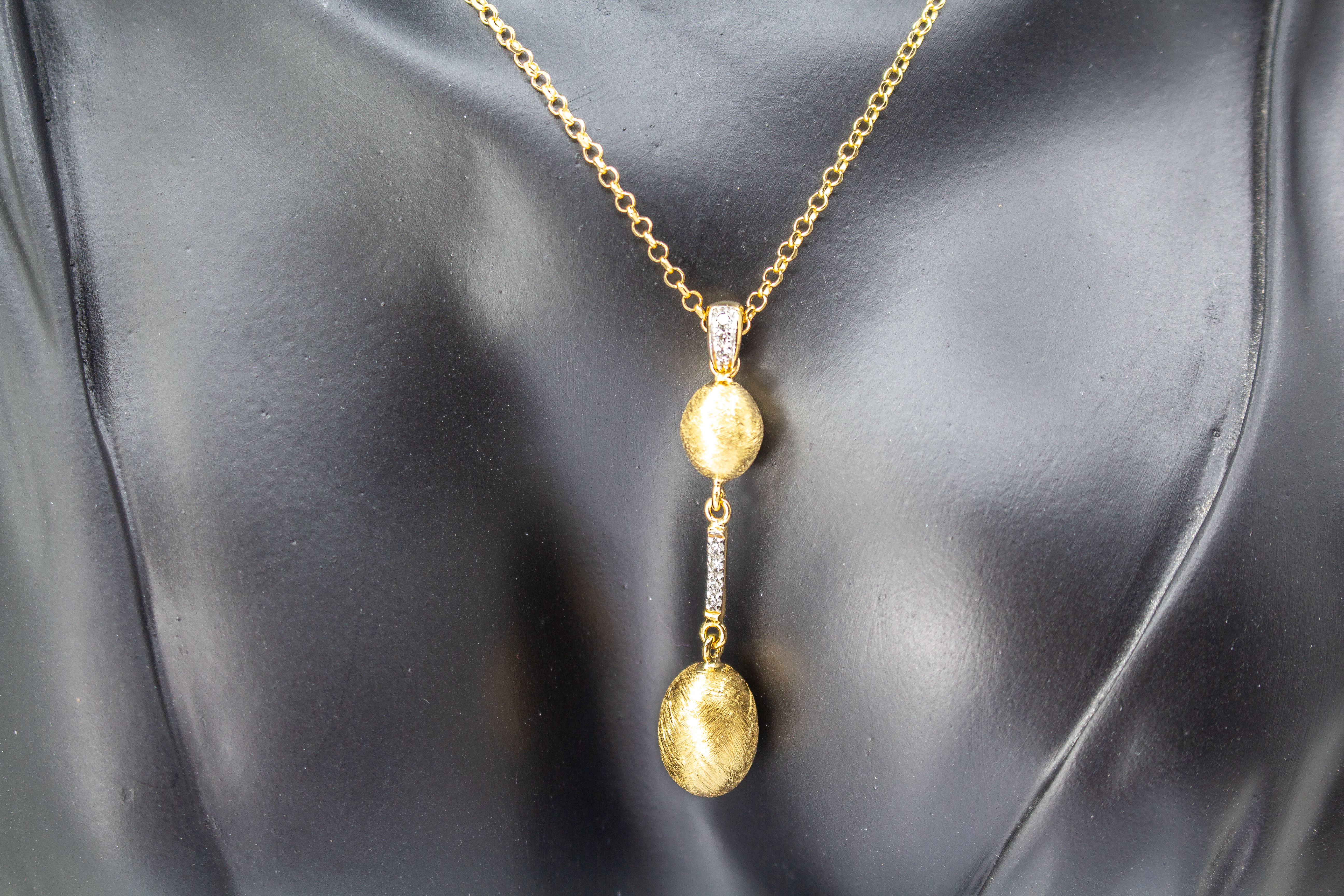 Elegante Halskette von Diva Gioielli aus vergoldetem 925 Silber mit zwei mattierten, ovalen Schmuckelementen, die durch einen mit funkelnden Zirkonia besetzten Steg verbunden sind.