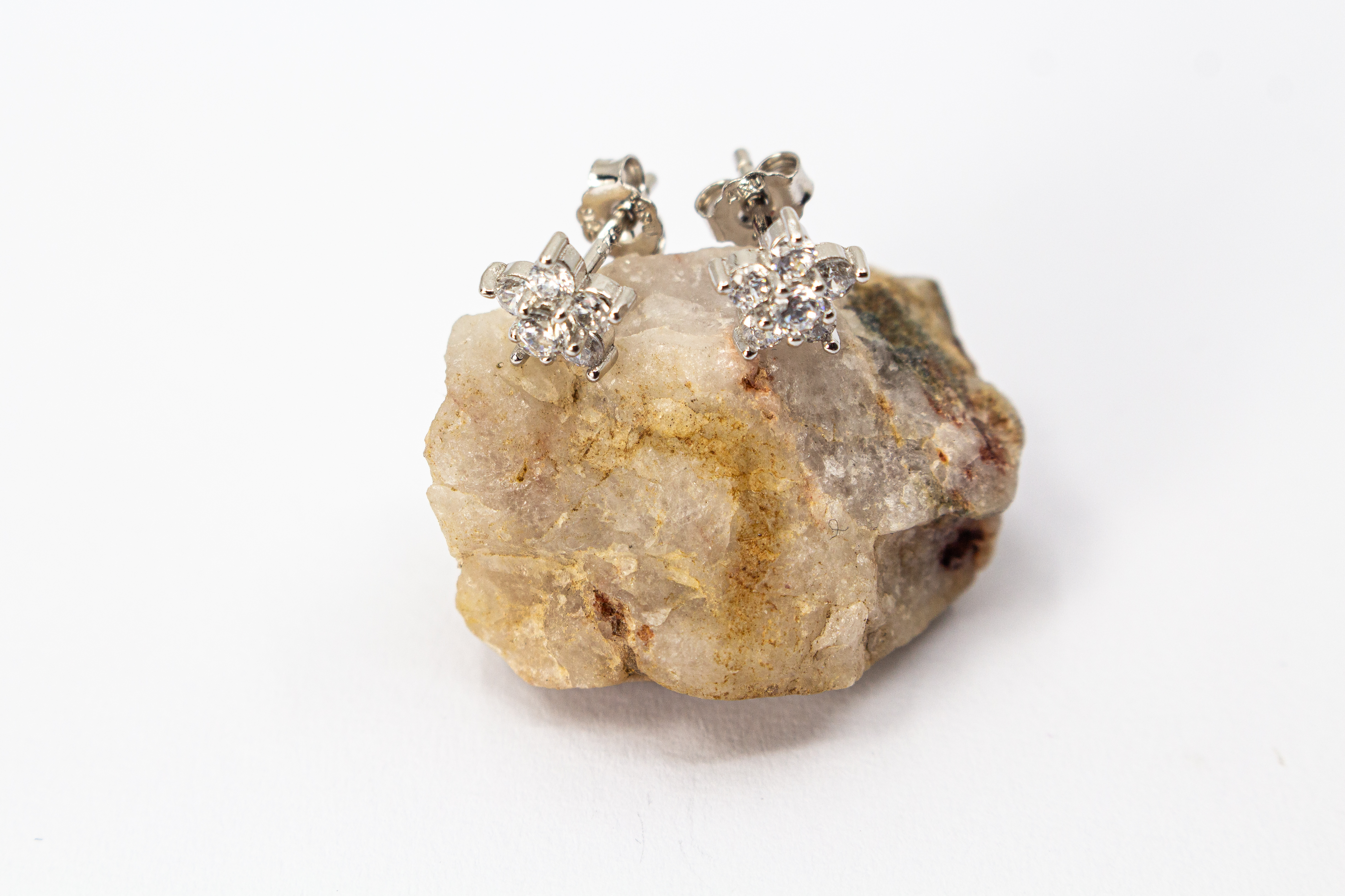 Filigrane Blumen-Ohrstecker aus rhodiniertem 925er Silber in Form einer kleinen Blüte mit funkelndem Zirkonia-Besatz im Onlineshop von Goldschmiede Regina Kraus.