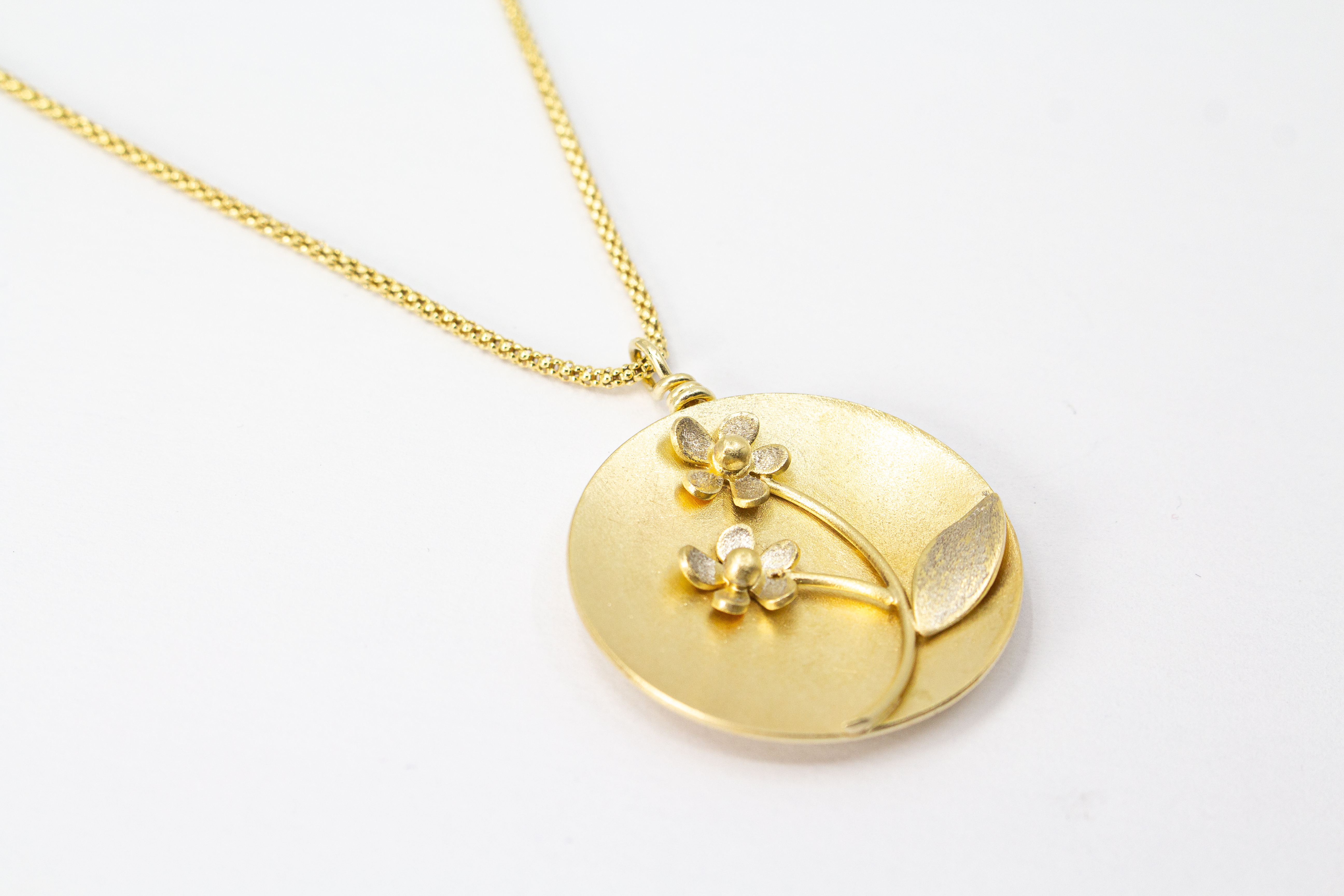 Feine Halskette mit rundem, matt vergoldetem Medaillon-Anhänger aus 20 Mikron plattiertem 925er Sterlingsilber, verziert mit einem plastischen Blumen-Motiv mit zwei Blüten und einem Blatt
