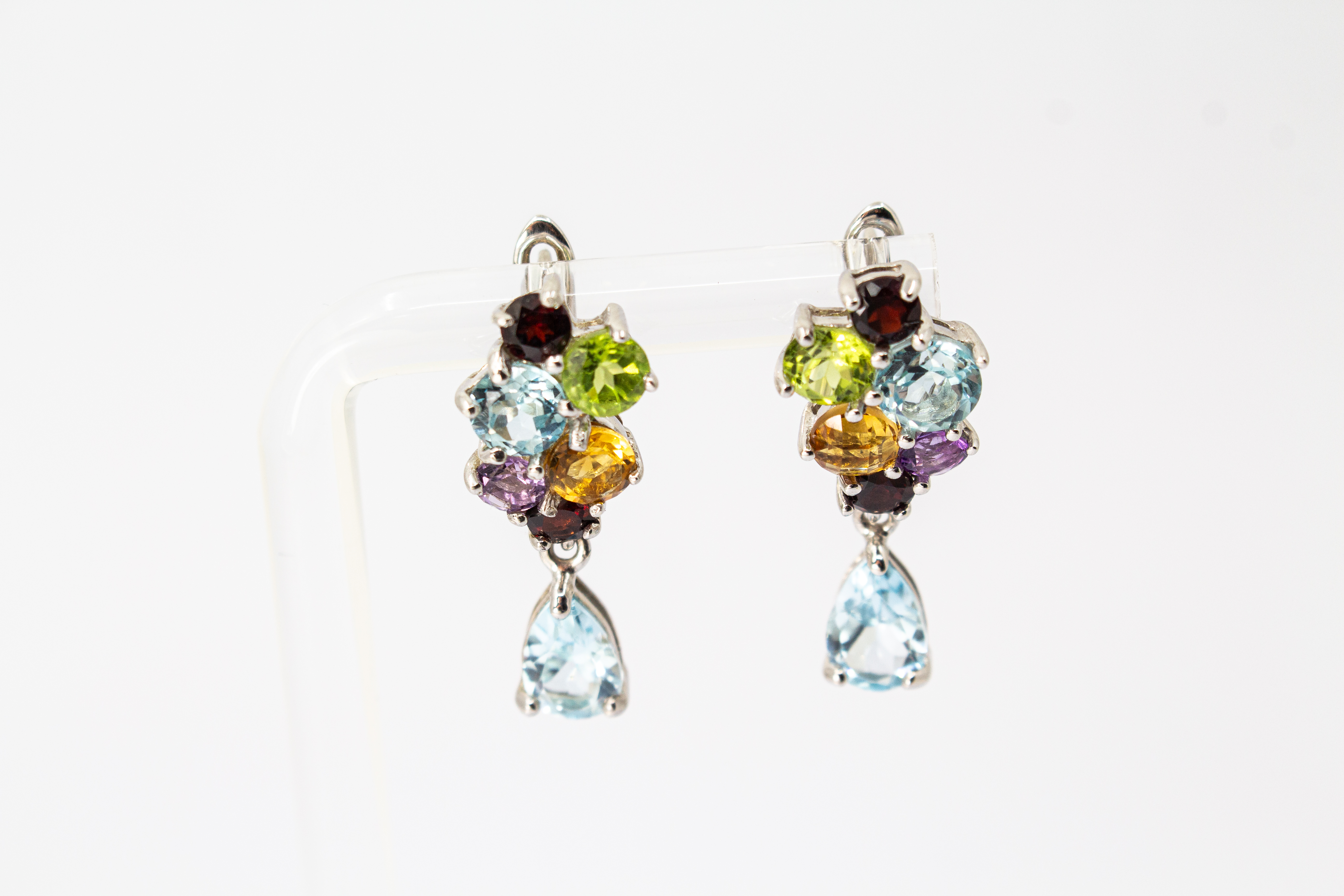 Elegante Multicolor-Edelstein-Ohrhänger aus rhodiniertem 925 Silber von der Goldschmiede Regina Kraus. Die detailreichen Ohrringe zeigen ein farbenfrohes Cluster aus rund facettierten Steinen wie Amethyst, Peridot, Citrin und Granat, gefolgt von einem bew