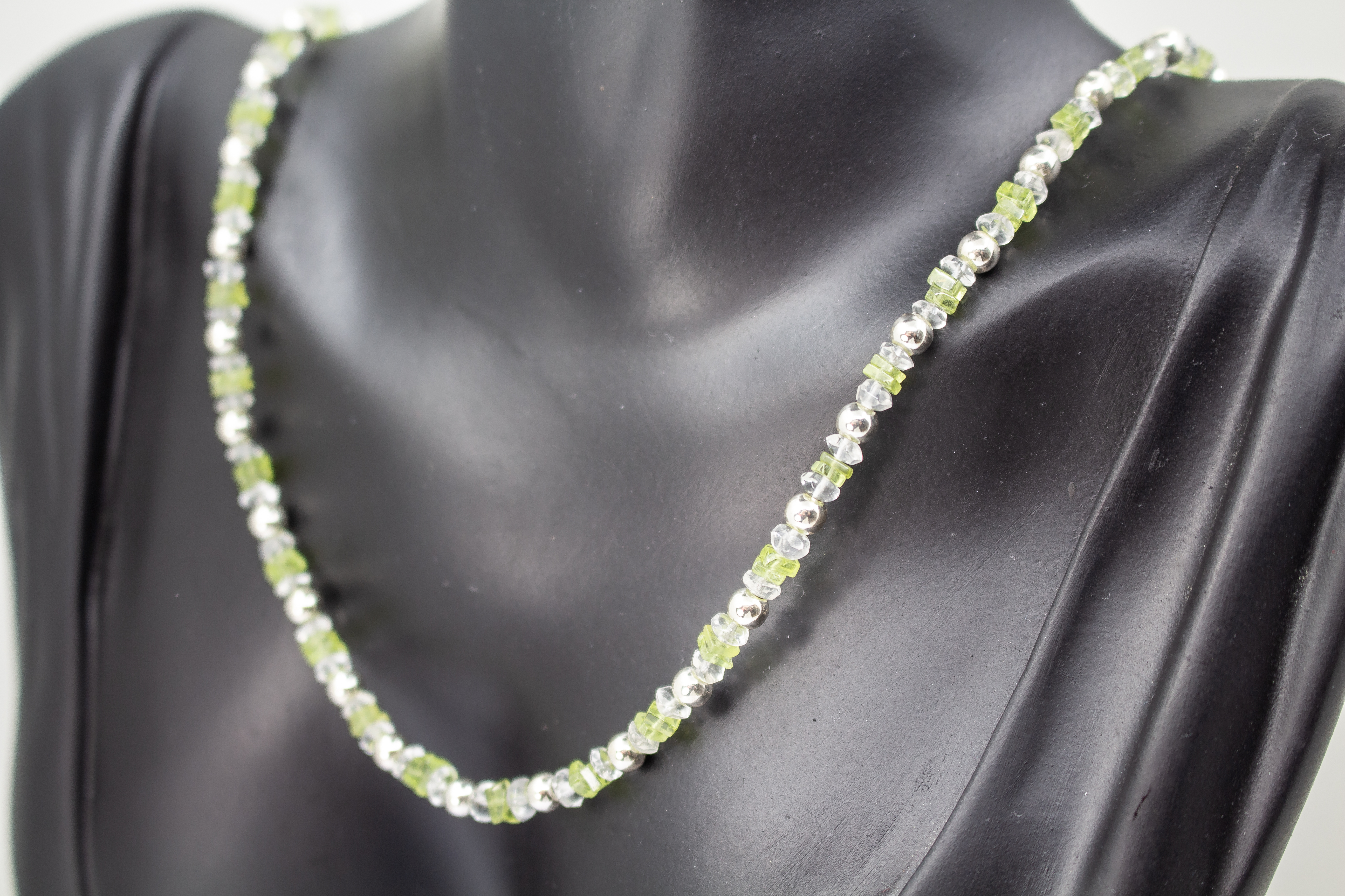 Filigrane Edelsteinhalskette aus hellgrünen Peridot-Splittern, klaren Bergkristall-Elementen und glänzenden 925 Sterling Silberkugeln aus dem Online-Shop der Goldschmiede Regina Kraus