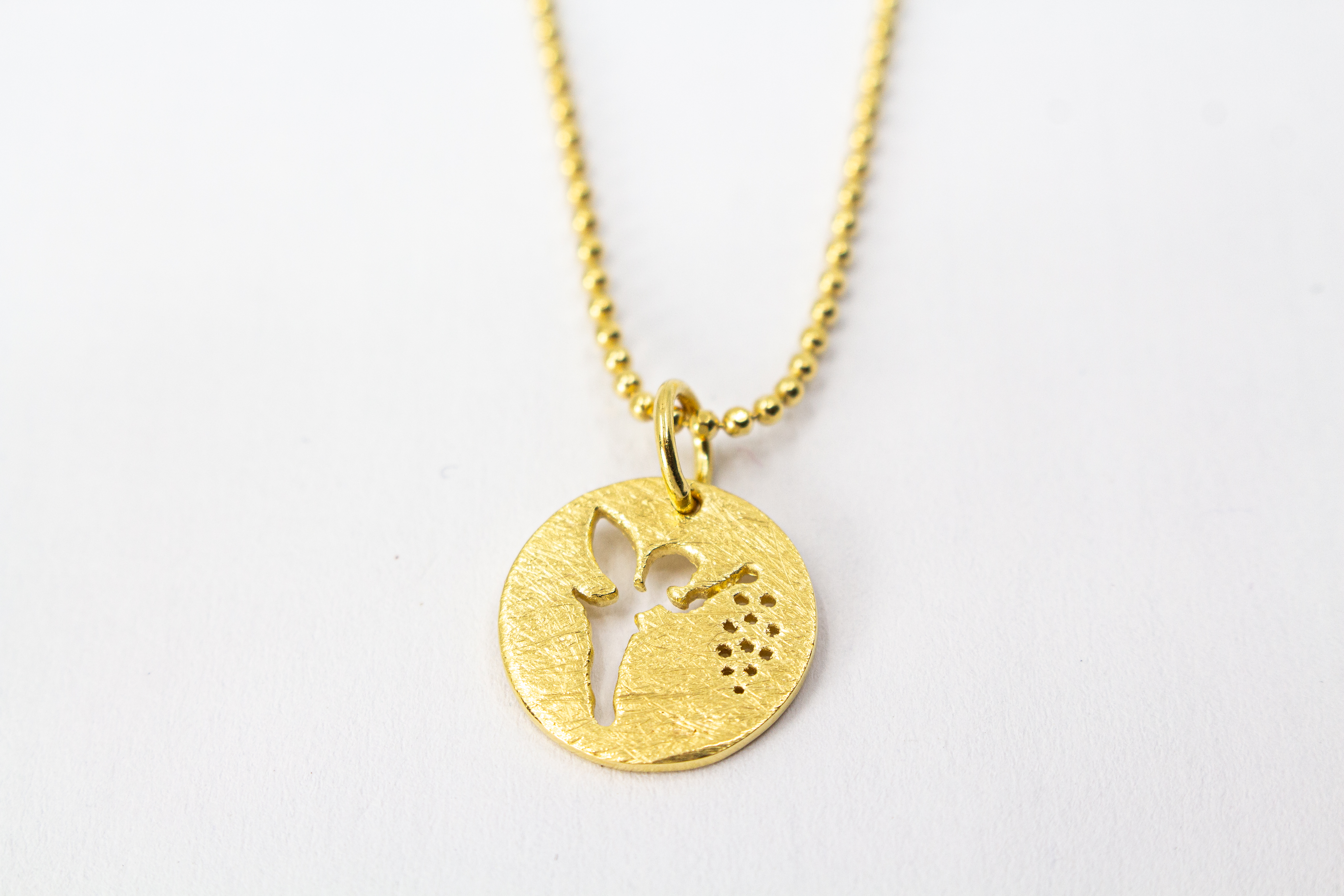 Goldene Kugelkette aus 20 Mikron vergoldetem 925er Sterlingsilber mit rundem Plättchen-Anhänger „Feenstaub“, der eine ausgestanzte Fee zeigt, aus dem Onlineshop der Goldschmiede Regina Kraus.