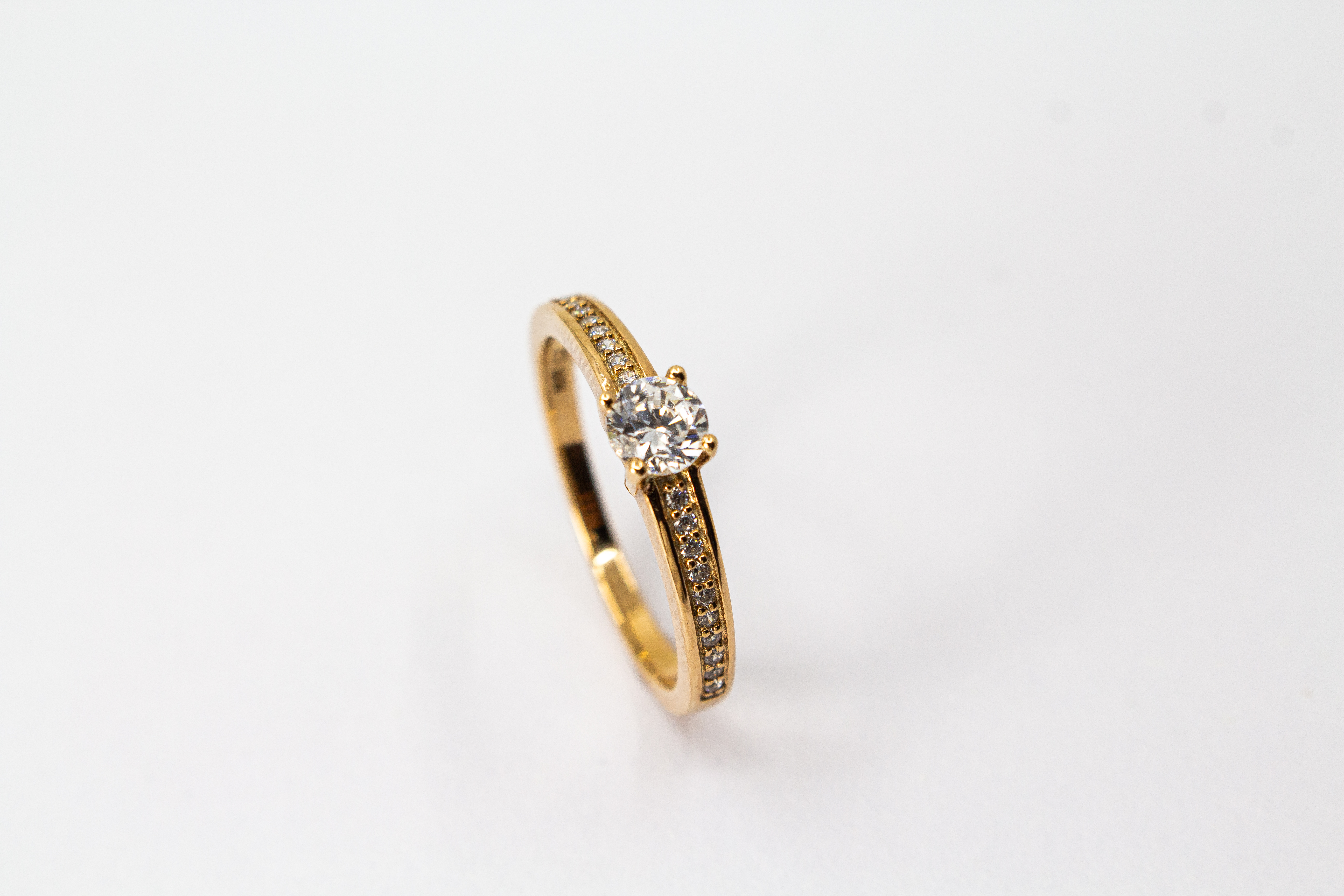 Eleganter Damenring aus rosévergoldetem 925 Sterling Silber mit einem großen, rund facettierten Zirkonia-Hauptstein in einer klassischen Vier-Krappenfassung und einer mit kleinen Zirkoniasteinen im Pavé-Stil besetzten Ringschiene aus dem Online-Shop der G