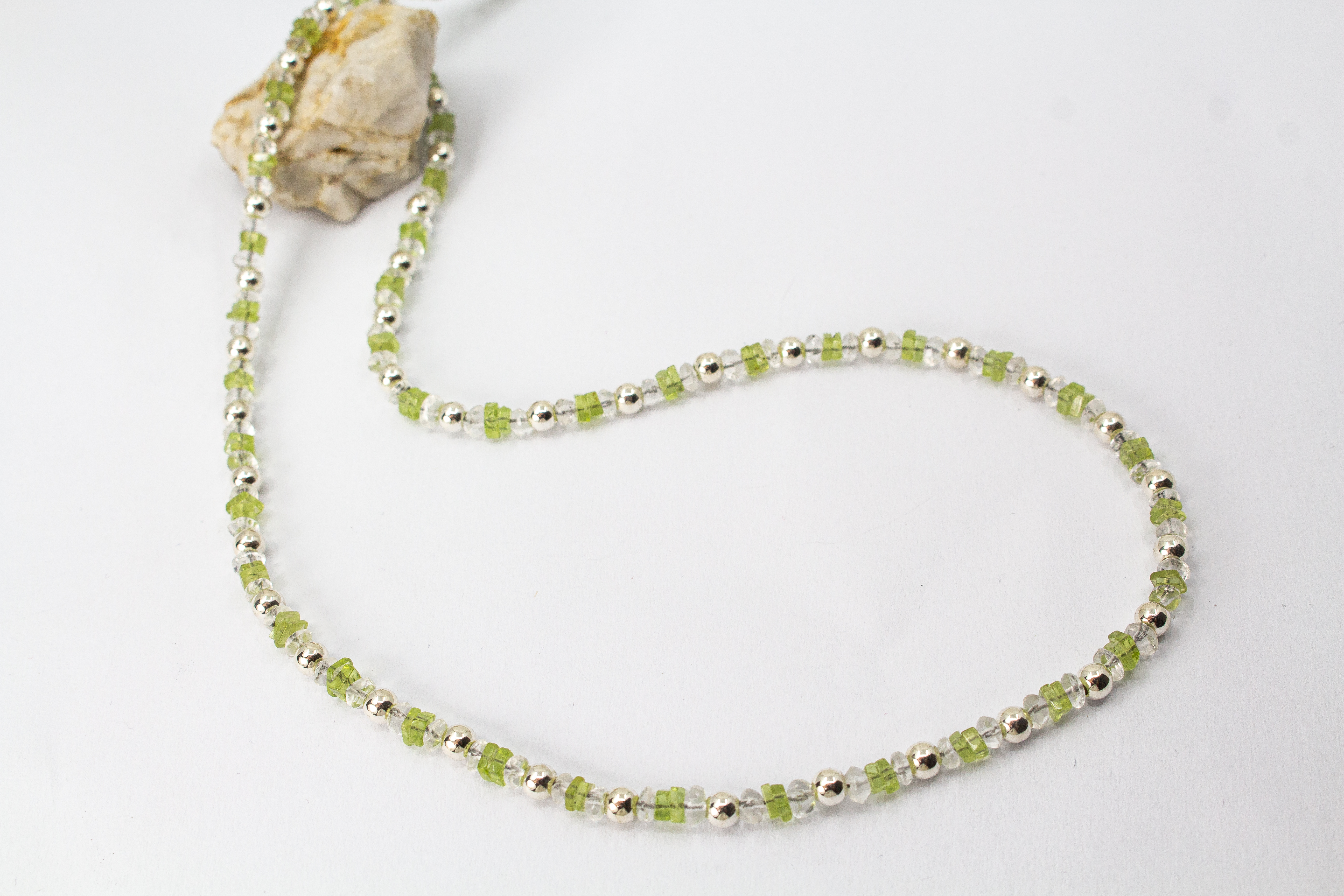 Filigrane Edelsteinhalskette aus hellgrünen Peridot-Splittern, klaren Bergkristall-Elementen und glänzenden 925 Sterling Silberkugeln aus dem Online-Shop der Goldschmiede Regina Kraus