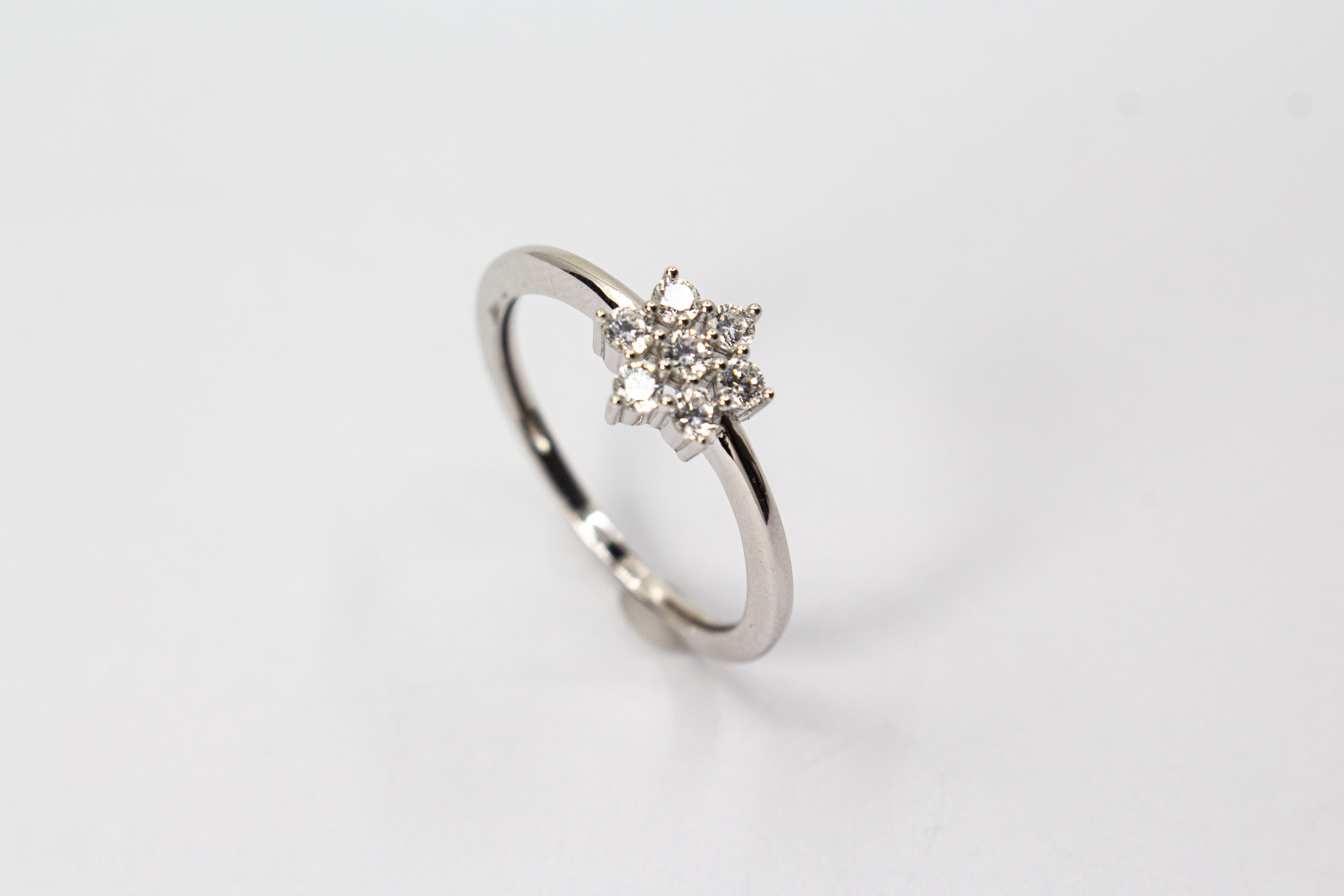 Rhodinierter 925er Sterlingsilber Ring „Schneestern“ mit funkelnden Zirkonia in sternförmiger Anordnung.