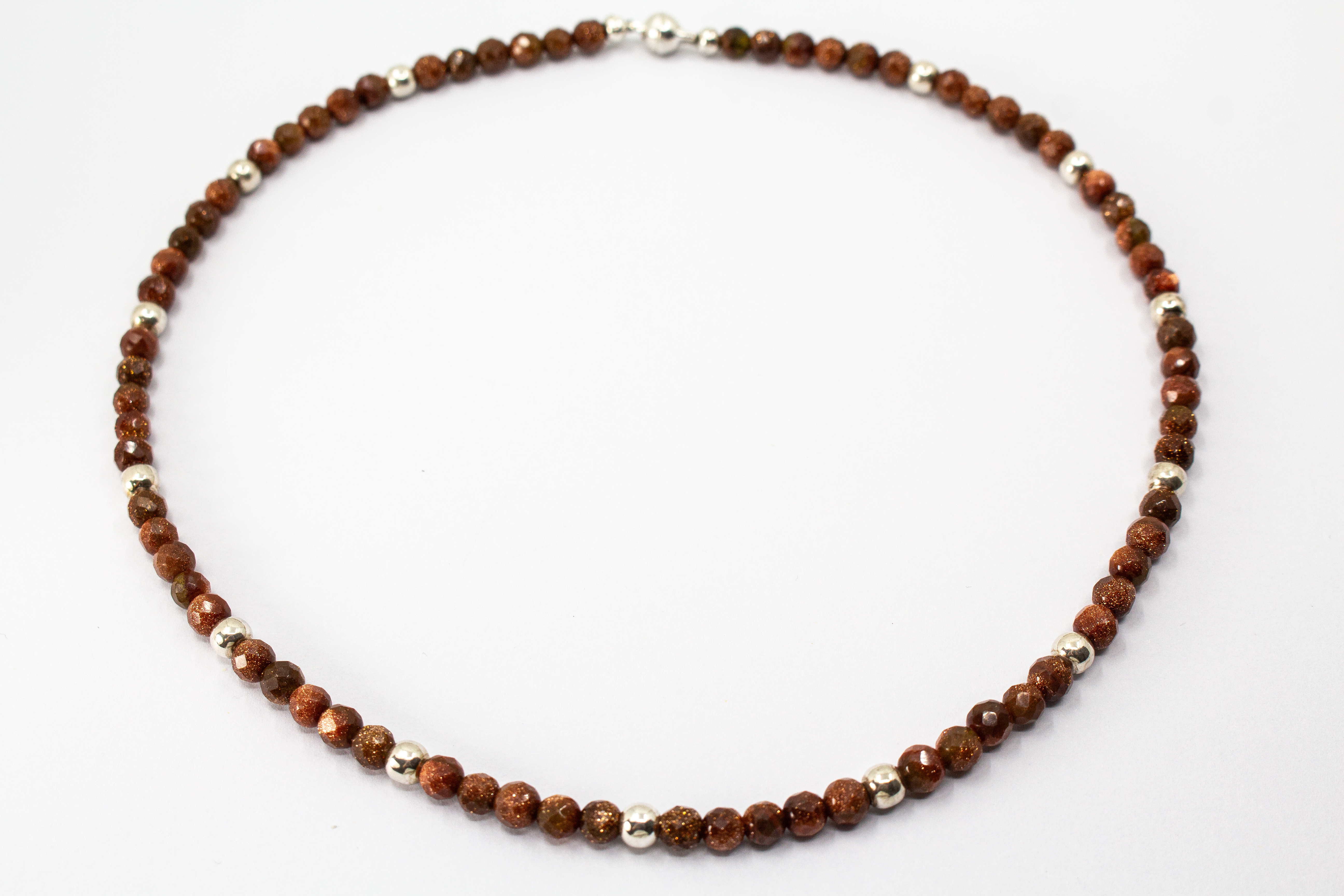 Collier „Goldflimmer“ aus facettiertem Goldfluss mit glänzenden Zwischenteilen aus 925er Sterlingsilber und funkelndem Goldschimmer.