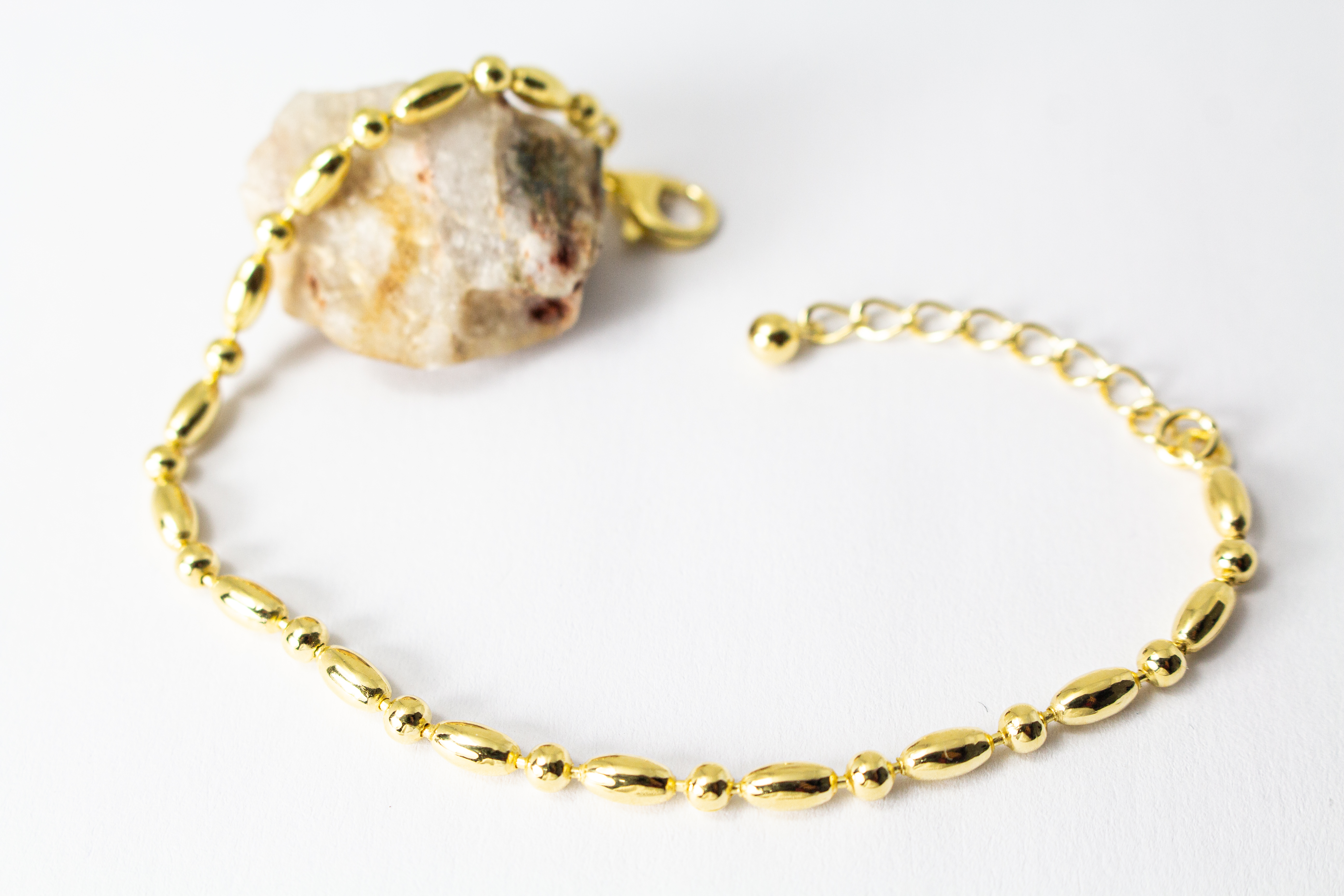 Filigranes, hochwertig vergoldetes Silberarmband (925er Silber, 20 Mikron Vergoldung) mit einem wechselnden Muster aus glänzenden Oliven- und Kugel-Elementen sowie Karabinerverschluss, erhältlich im Onlineshop der Goldschmiede Regina Kraus.