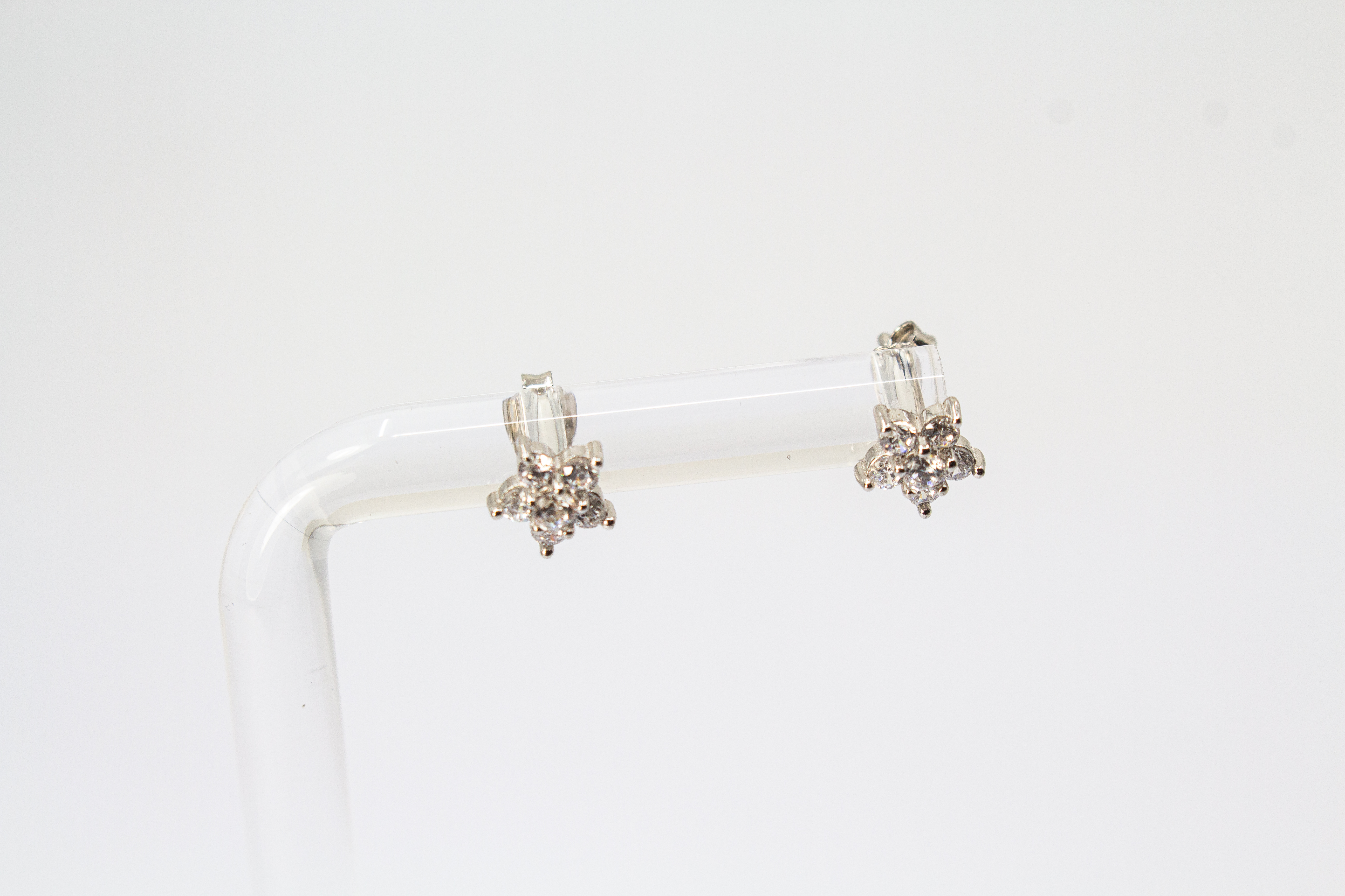 Filigrane Blumen-Ohrstecker aus rhodiniertem 925er Silber in Form einer kleinen Blüte mit funkelndem Zirkonia-Besatz im Onlineshop von Goldschmiede Regina Kraus.