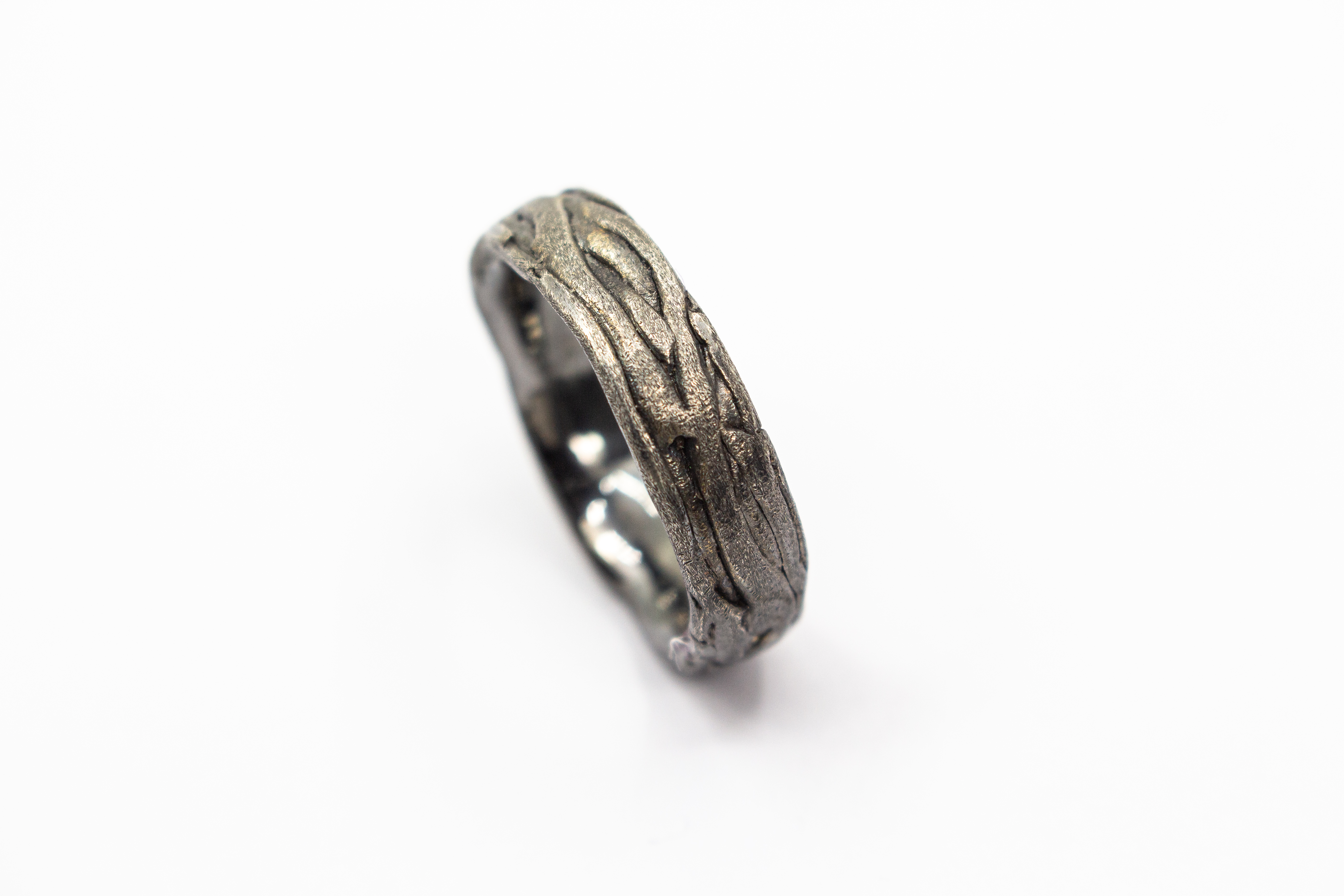 Markanter, strukturierter Bandring aus dunkel geschwärztem und oxidiertem 925 Sterlingsilber mit einer organisch geflochtenen Oberfläche im Ast- oder Rinden-Design aus dem Online-Shop der Goldschmiede Regina Kraus.
