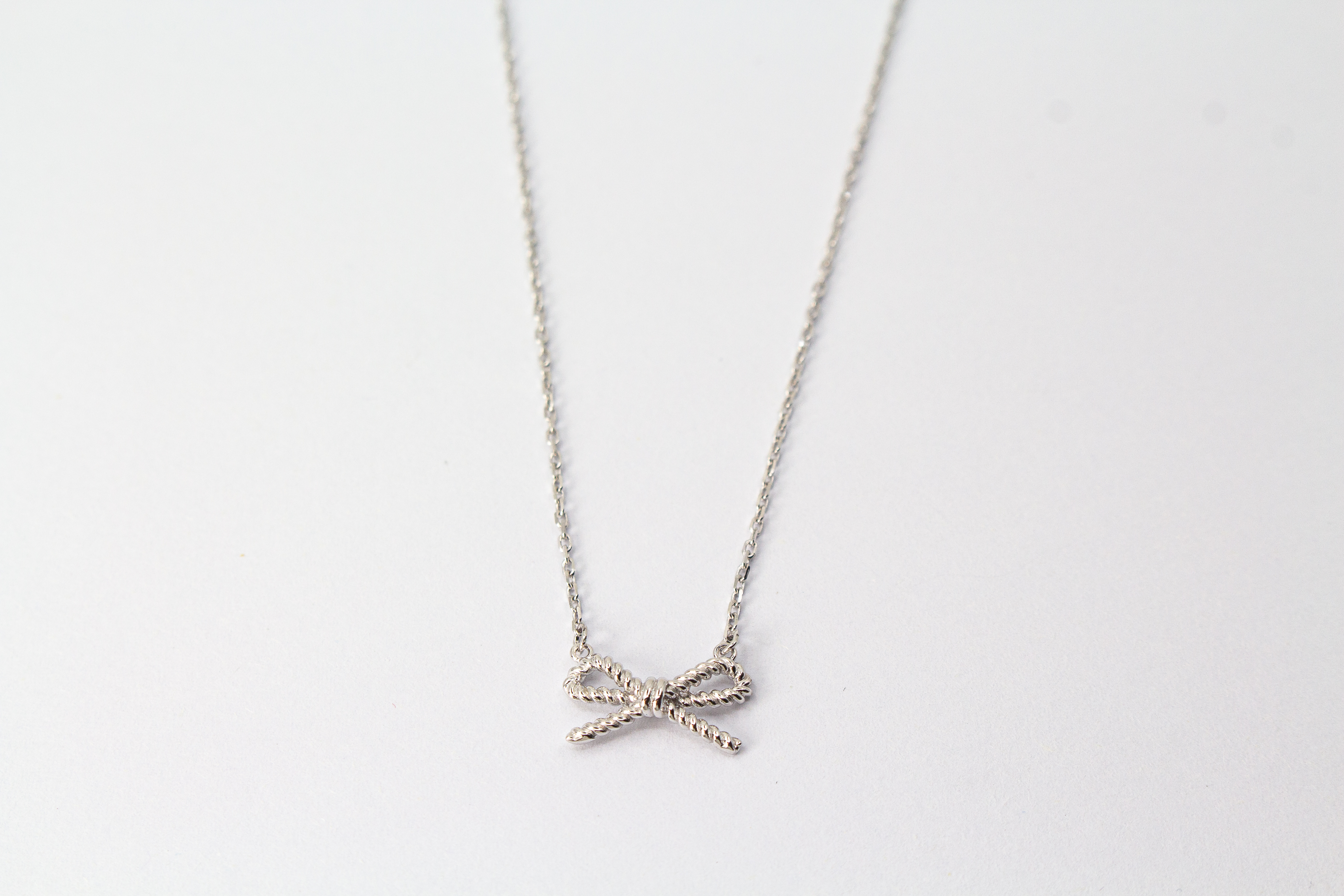 Collier „Schleifenzauber“ aus rhodiniertem 925er Sterlingsilber mit filigranem Schleifenanhänger in zeitlosem Design.