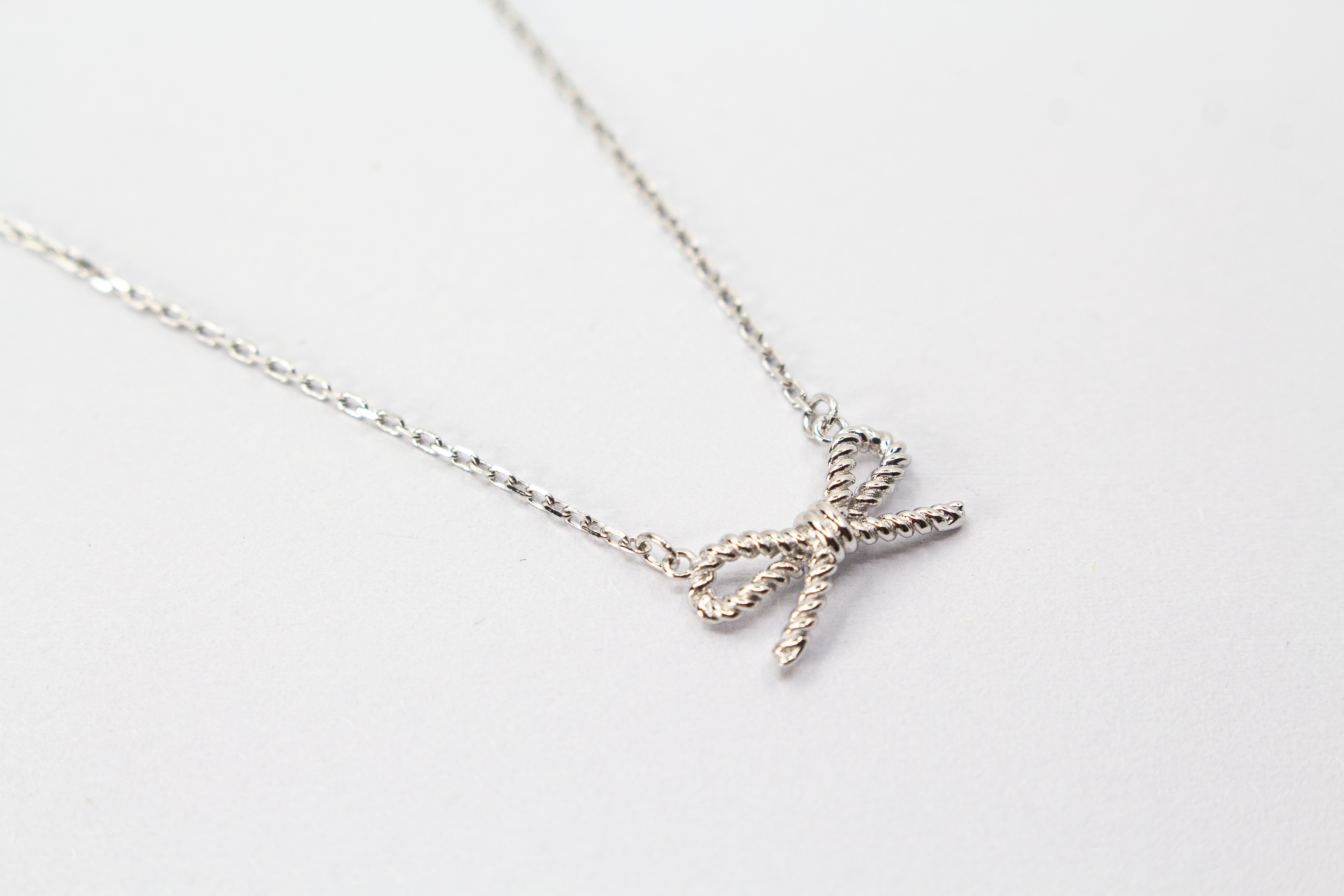 Collier „Schleifenzauber“ aus rhodiniertem 925er Sterlingsilber mit filigranem Schleifenanhänger in zeitlosem Design.