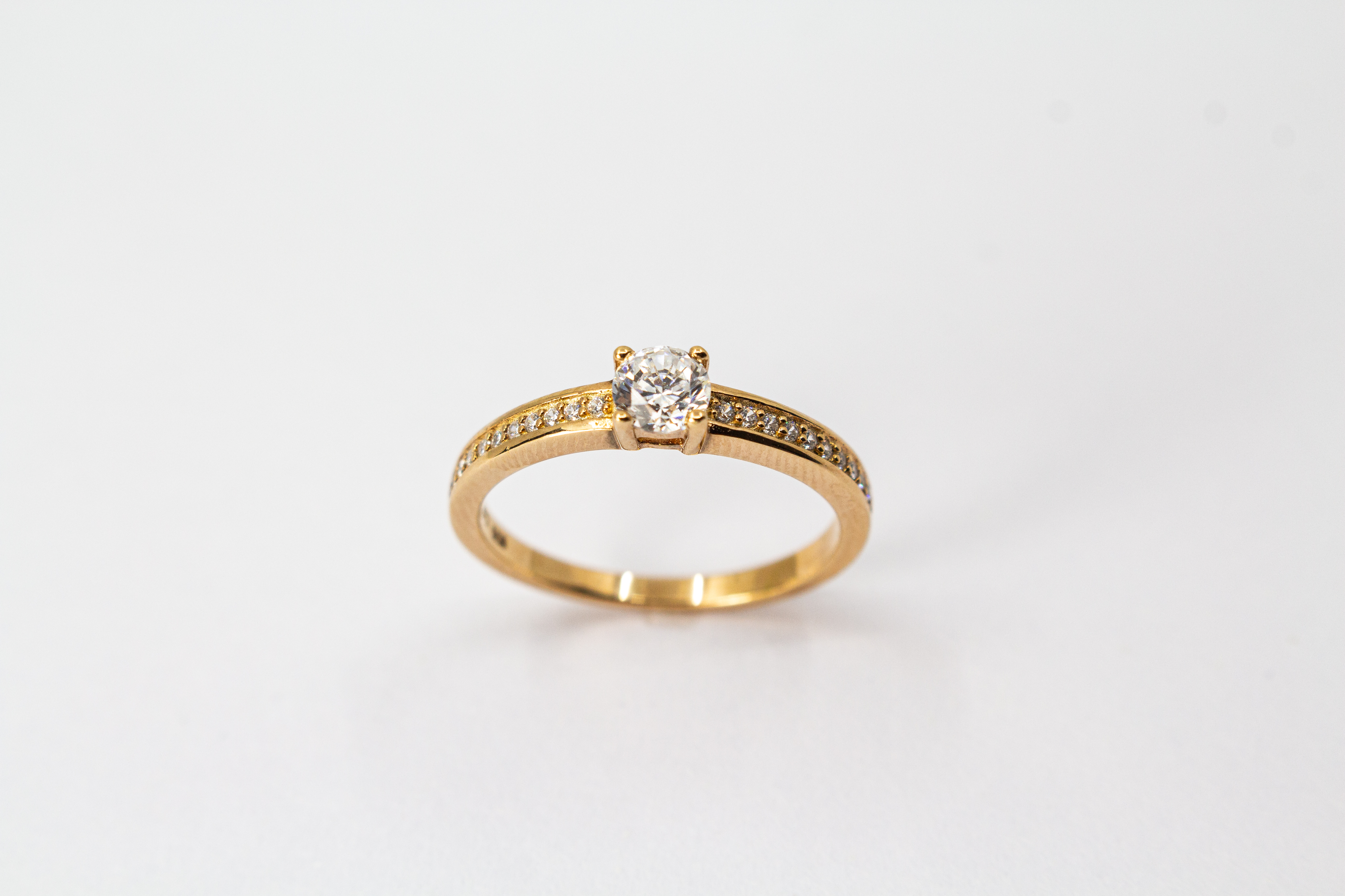 Eleganter Damenring aus rosévergoldetem 925 Sterling Silber mit einem großen, rund facettierten Zirkonia-Hauptstein in einer klassischen Vier-Krappenfassung und einer mit kleinen Zirkoniasteinen im Pavé-Stil besetzten Ringschiene aus dem Online-Shop der G