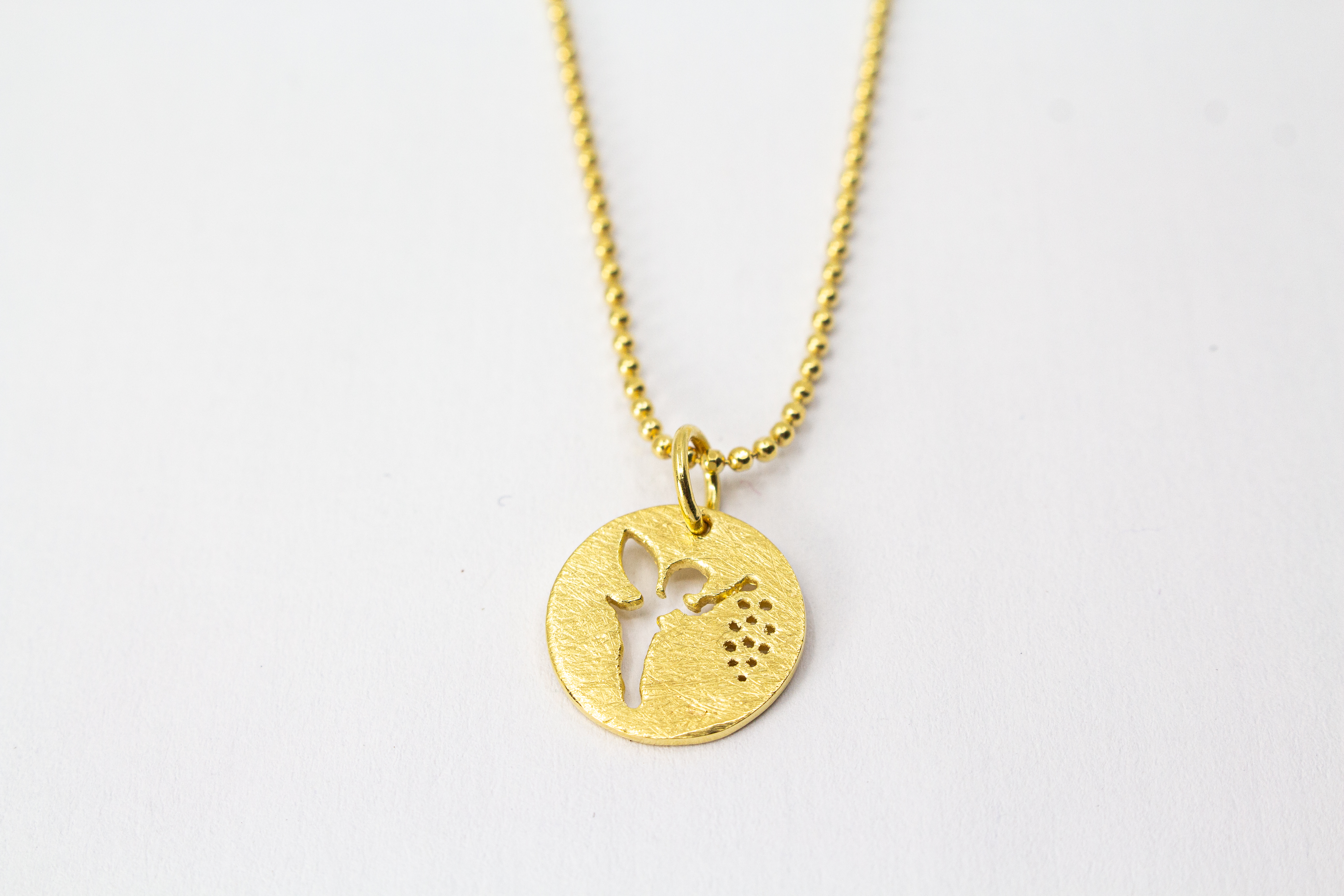 Goldene Kugelkette aus 20 Mikron vergoldetem 925er Sterlingsilber mit rundem Plättchen-Anhänger „Feenstaub“, der eine ausgestanzte Fee zeigt, aus dem Onlineshop der Goldschmiede Regina Kraus.
