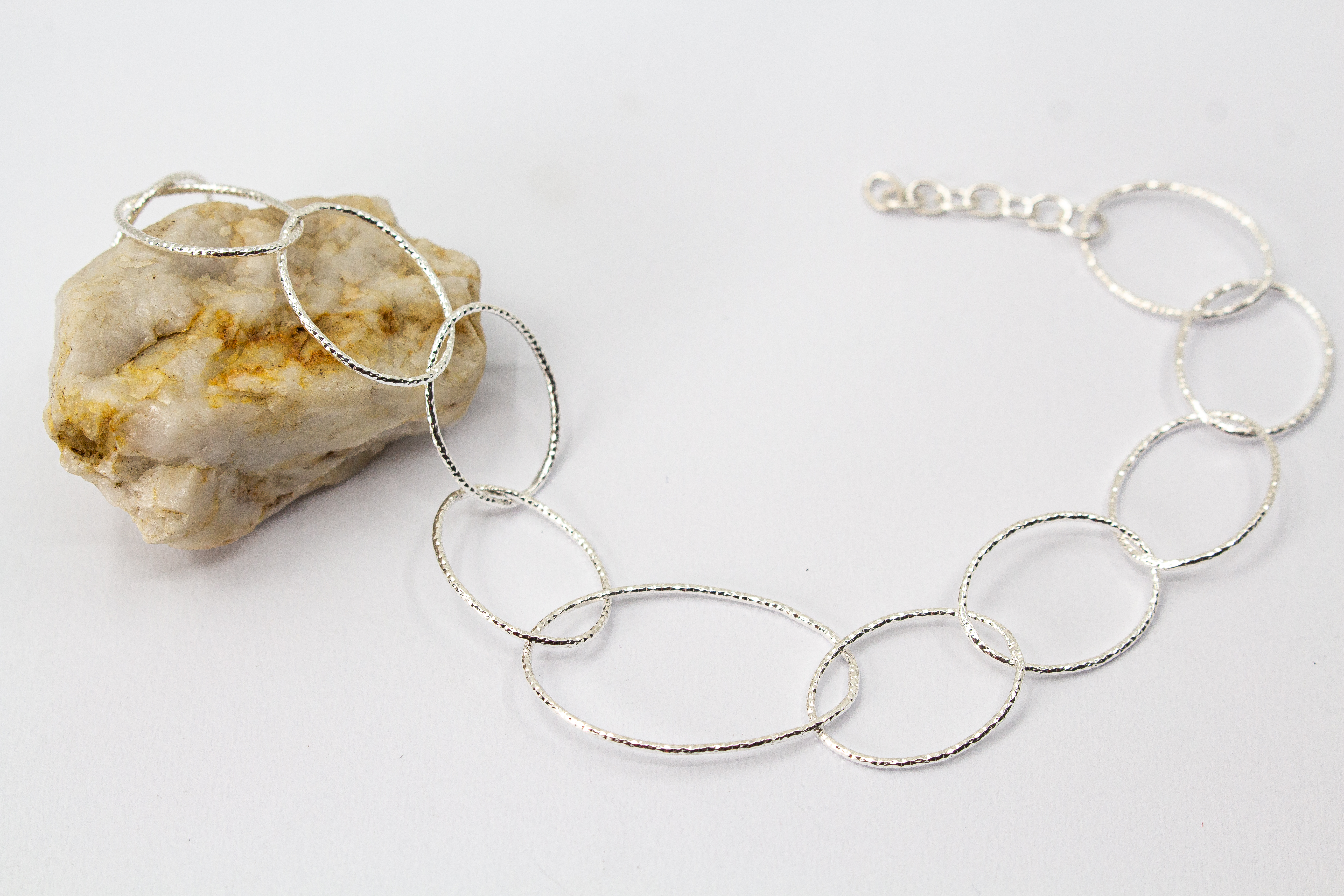Filigranes Gliederarmband aus 925er Silber mit unterschiedlich großen, strukturierten Ring-Elementen im Onlineshop von Goldschmiede Regina Kraus.