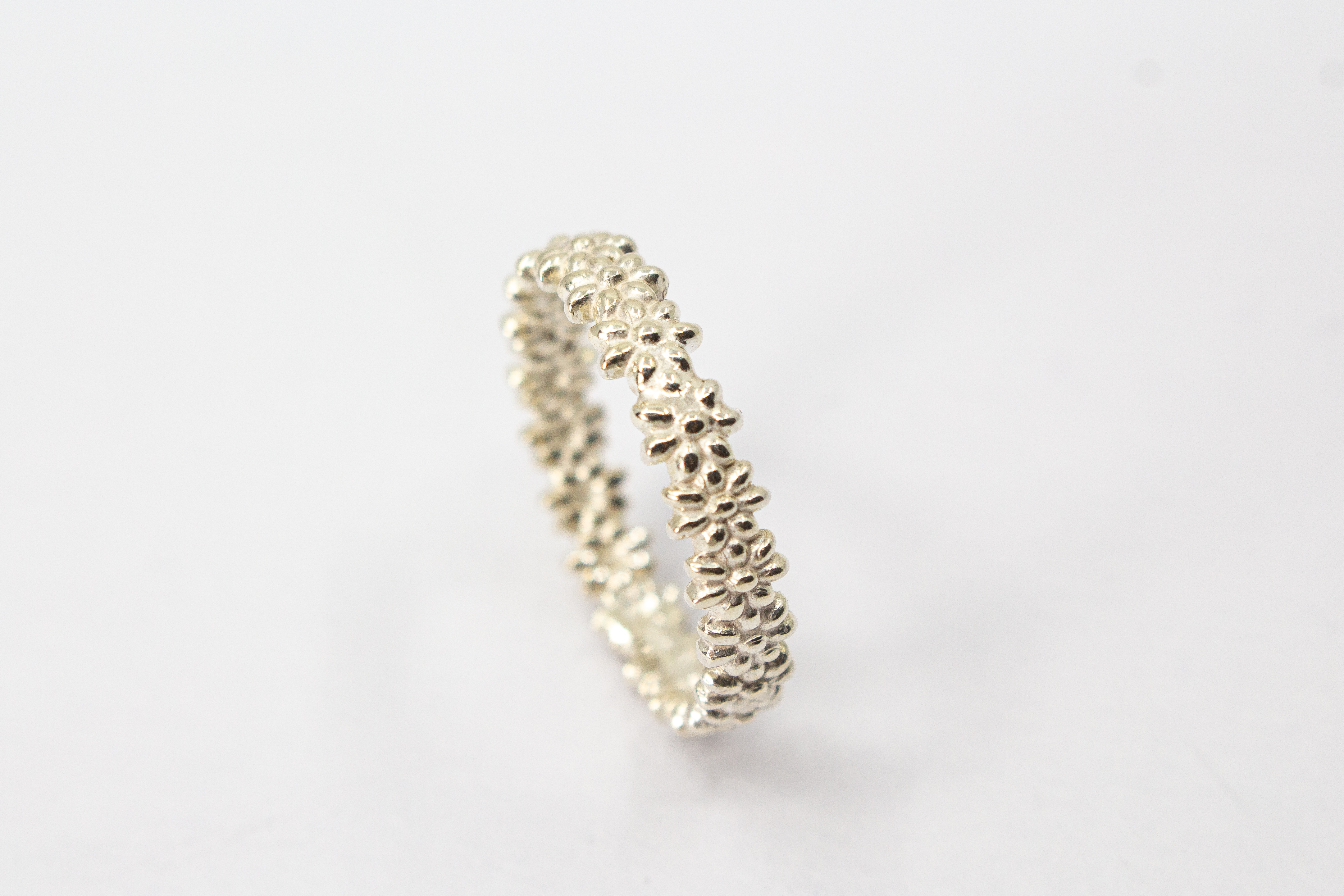 Schmaler, filigraner Ring aus 925 Sterling Silber mit einem rundherum verlaufenden, detaillierten Blütenmuster von der Goldschmiede Regina Kraus