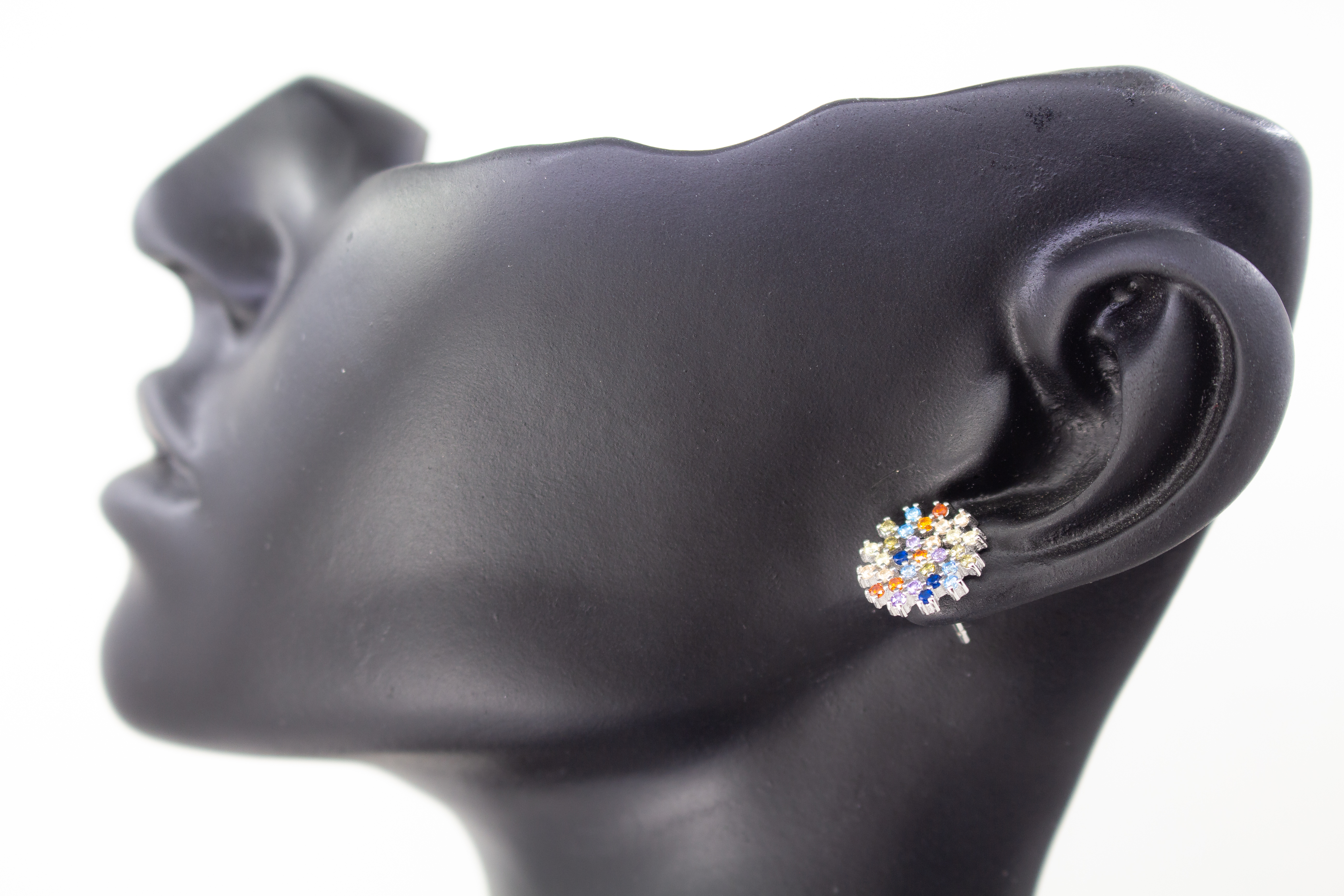 Die filigranen 925er Silber-Ohrstecker „Fleur de Lumière“ aus der Goldschmiede Regina Kraus, präsentiert auf einem transparenten Schmuckständer. Das florale Design erinnert an eine funkelnde Lichtblume und ist kunstvoll mit kleinen, bunt strahlenden Zirk