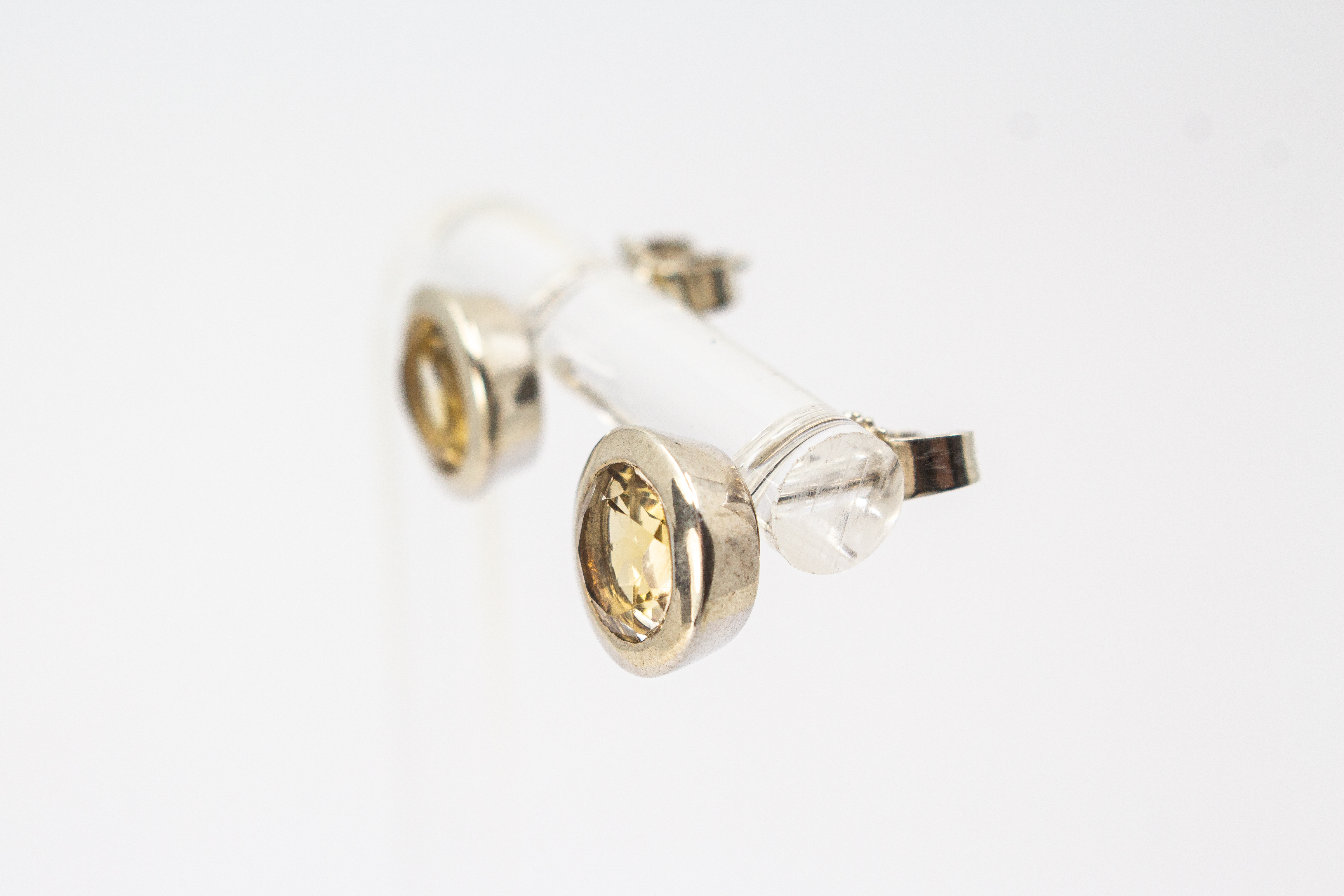 klassische, runde Ohrstecker aus glänzendem 925 Sterling Silber mit einem facettierten, hellgelben Citrin-Edelstein in einer glatten Zargenfassung aus dem Online-Shop der Goldschmiede Regina Kraus.