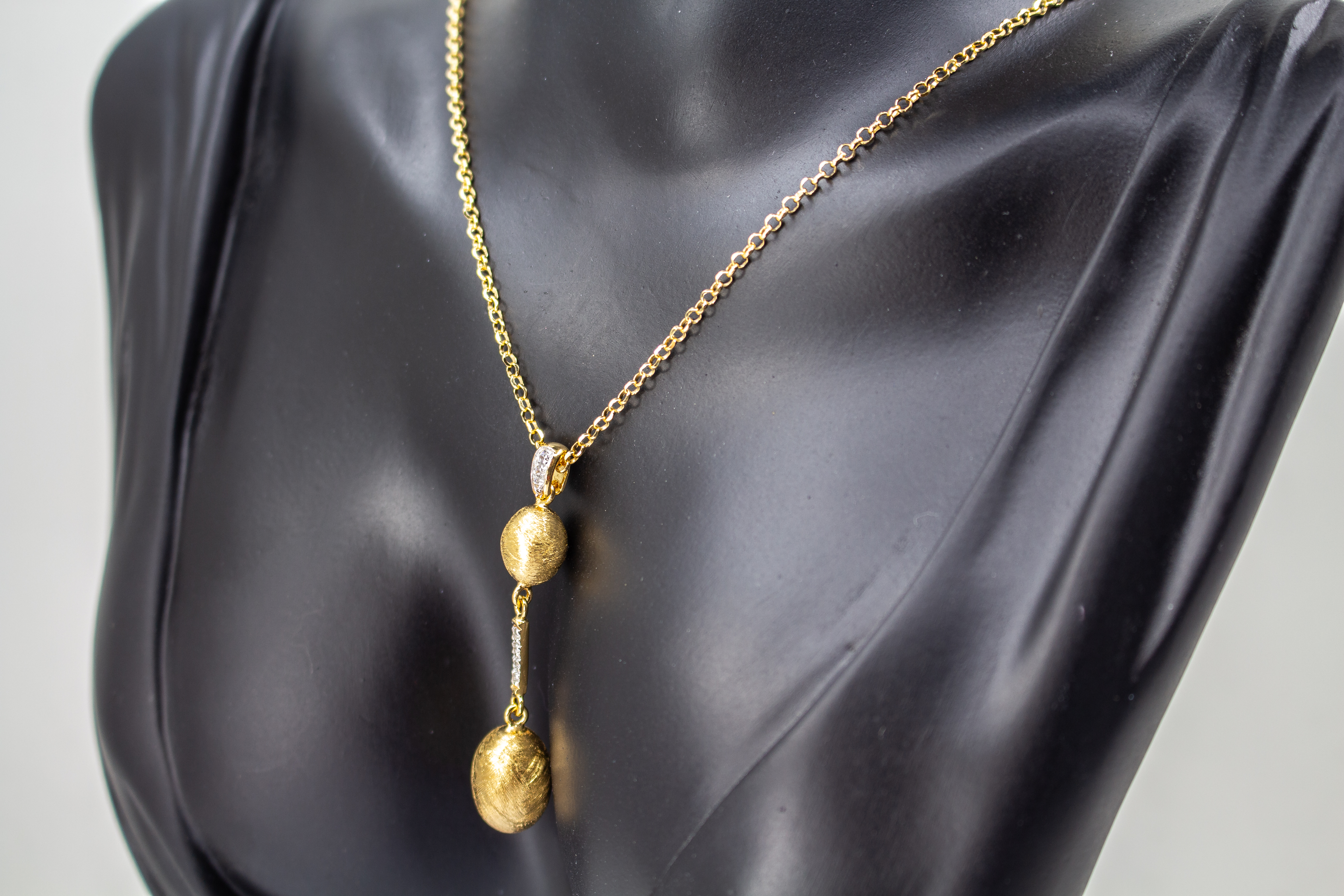 Elegante Halskette von Diva Gioielli aus vergoldetem 925 Silber mit zwei mattierten, ovalen Schmuckelementen, die durch einen mit funkelnden Zirkonia besetzten Steg verbunden sind.