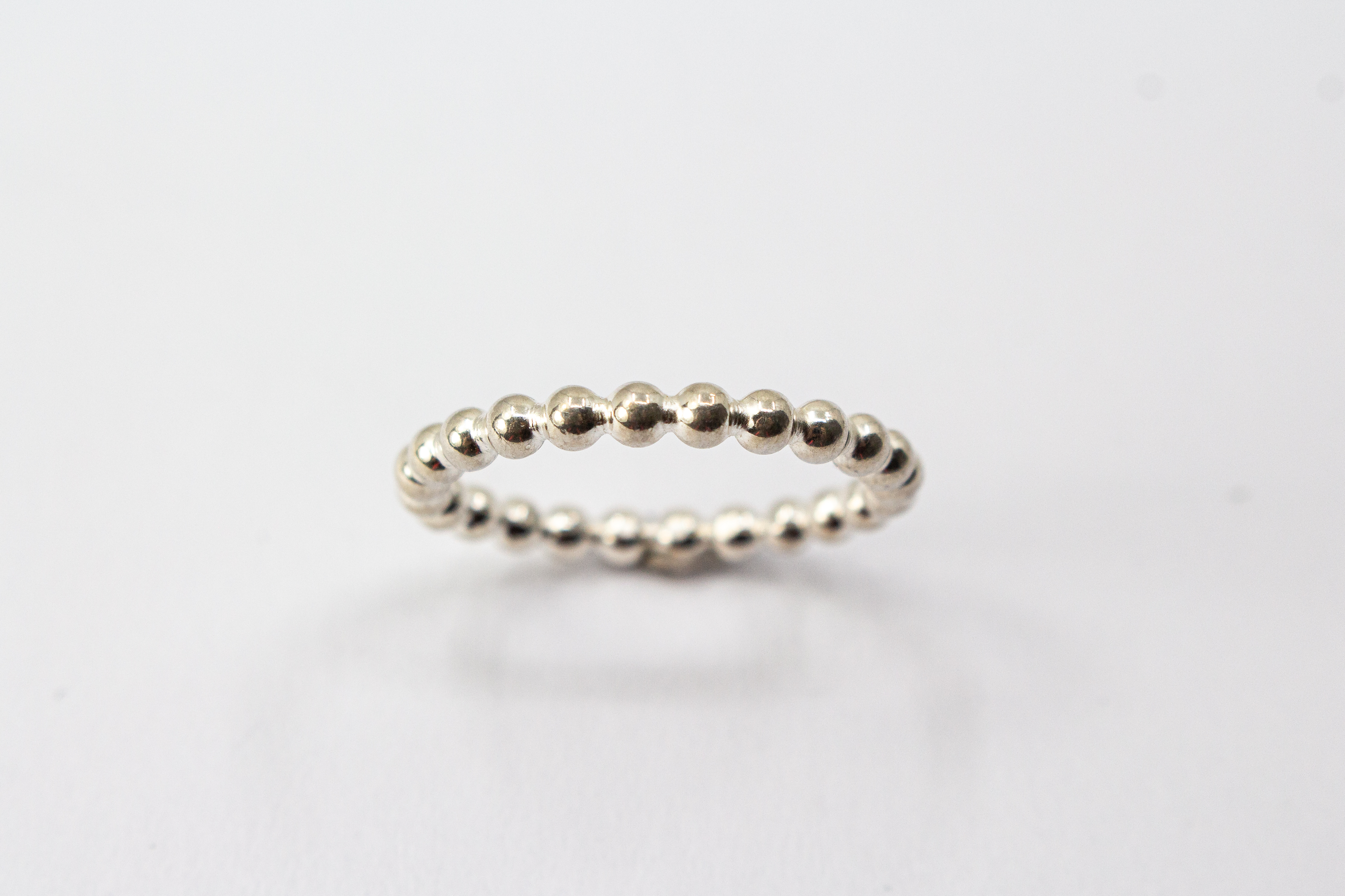 Handgefertigter Kugelring aus glänzendem 925 Sterlingsilber im filigranen Perldraht-Design – minimalistischer Stapelring aus der Goldschmiede Regina Kraus.