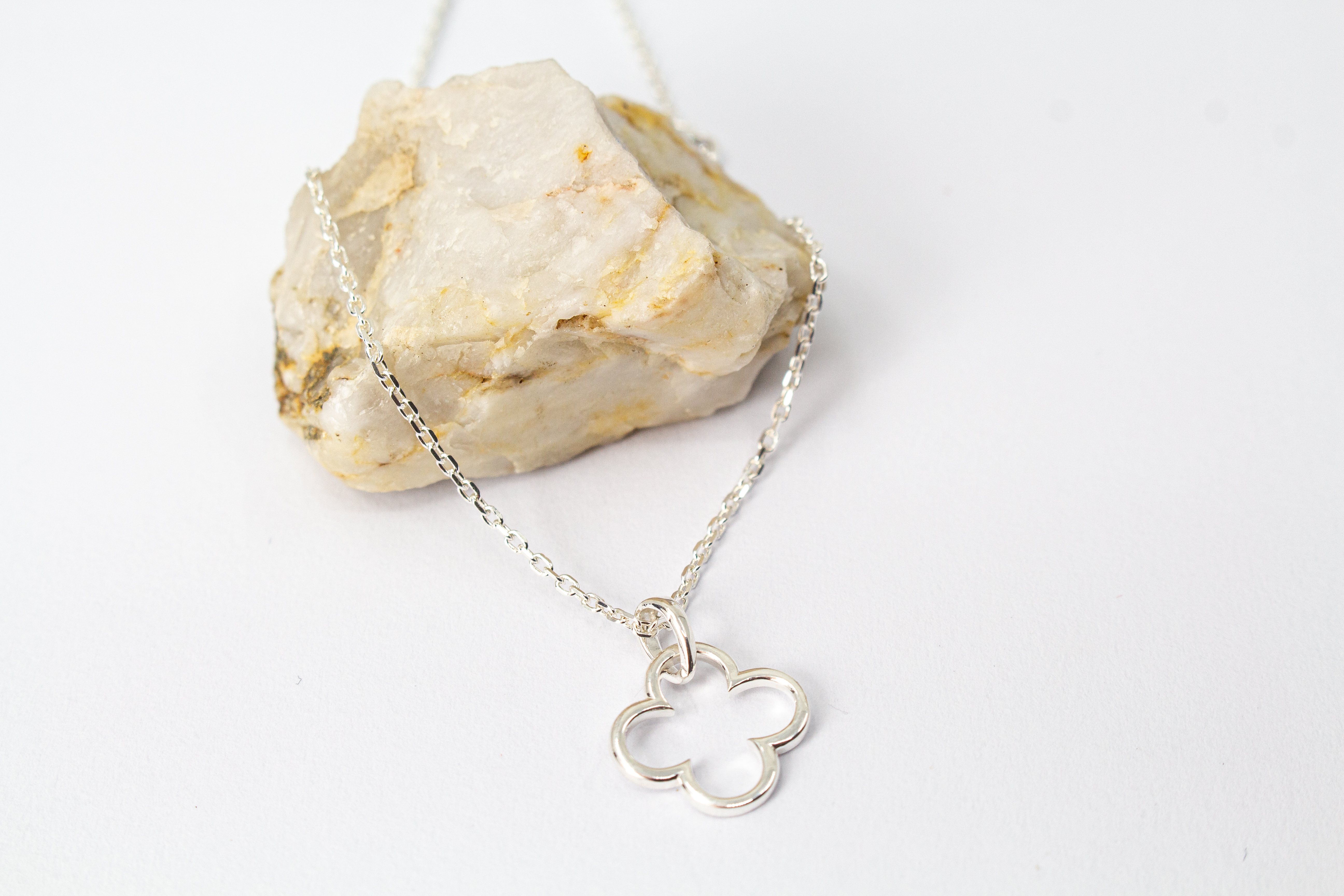 Zarte Damen-Halskette aus 925er Sterling Silber mit einem feinen, offenen Kleeblatt-Anhänger und zwei kleinen integrierten Stationselementen an den Seiten – eleganter Glücksbringer-Schmuck von der Goldschmiede Regina Kraus.