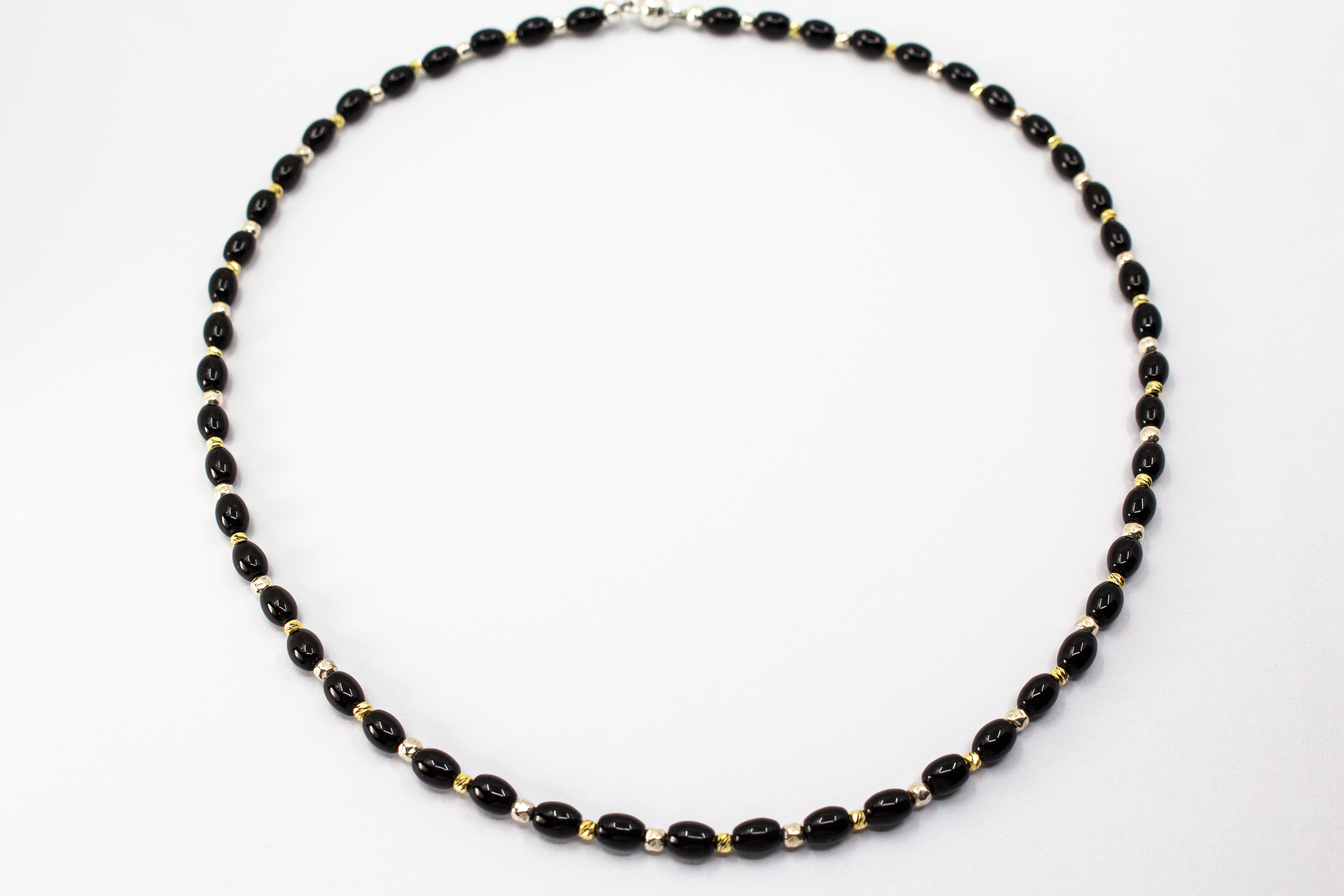 Elegante Onyx Kette „Mitternachtsglanz“ mit schwarzen Onyx-Perlen, Zwischenteilen aus 925er Sterlingsilber und vergoldeten Silberdetails.