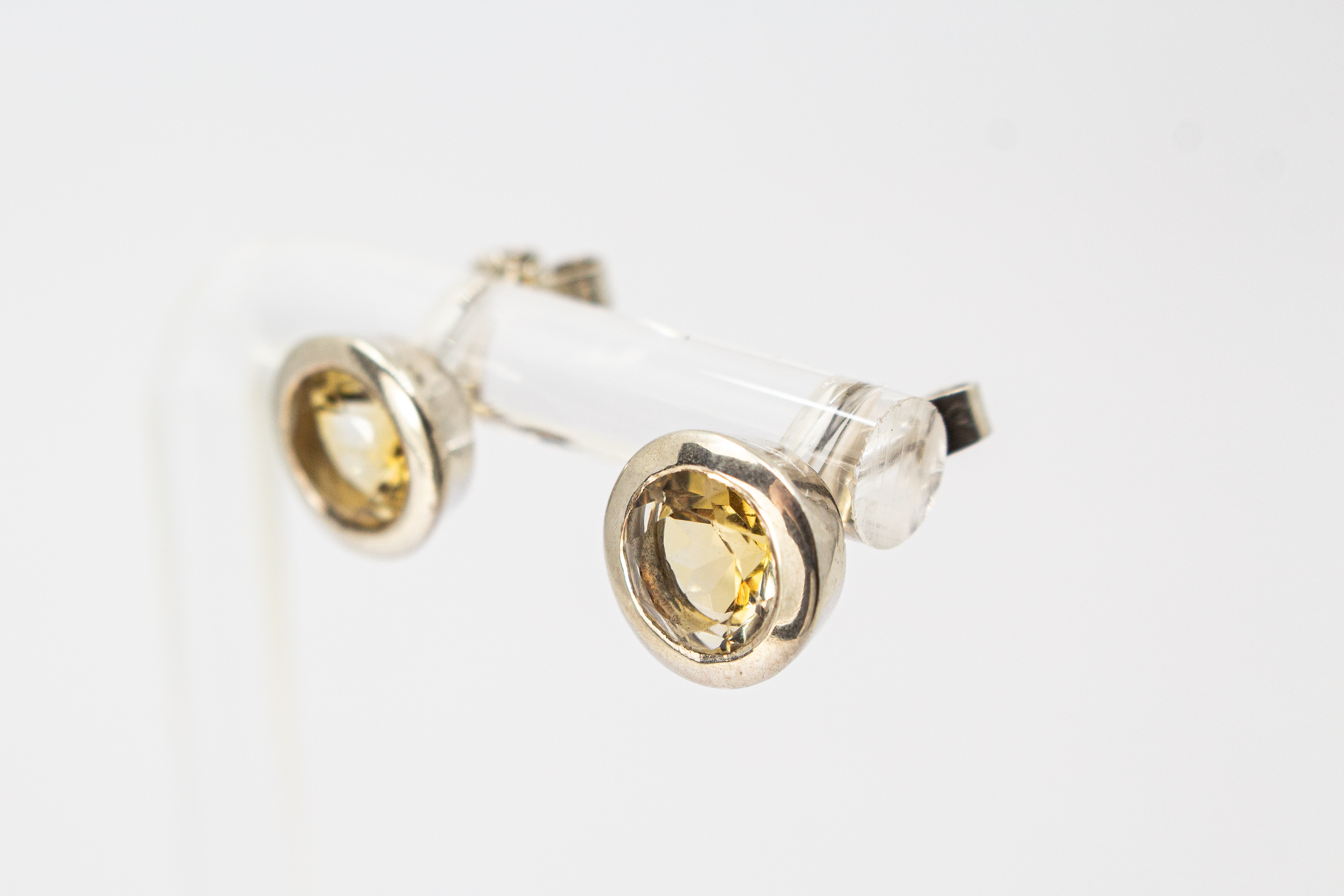 klassische, runde Ohrstecker aus glänzendem 925 Sterling Silber mit einem facettierten, hellgelben Citrin-Edelstein in einer glatten Zargenfassung aus dem Online-Shop der Goldschmiede Regina Kraus.