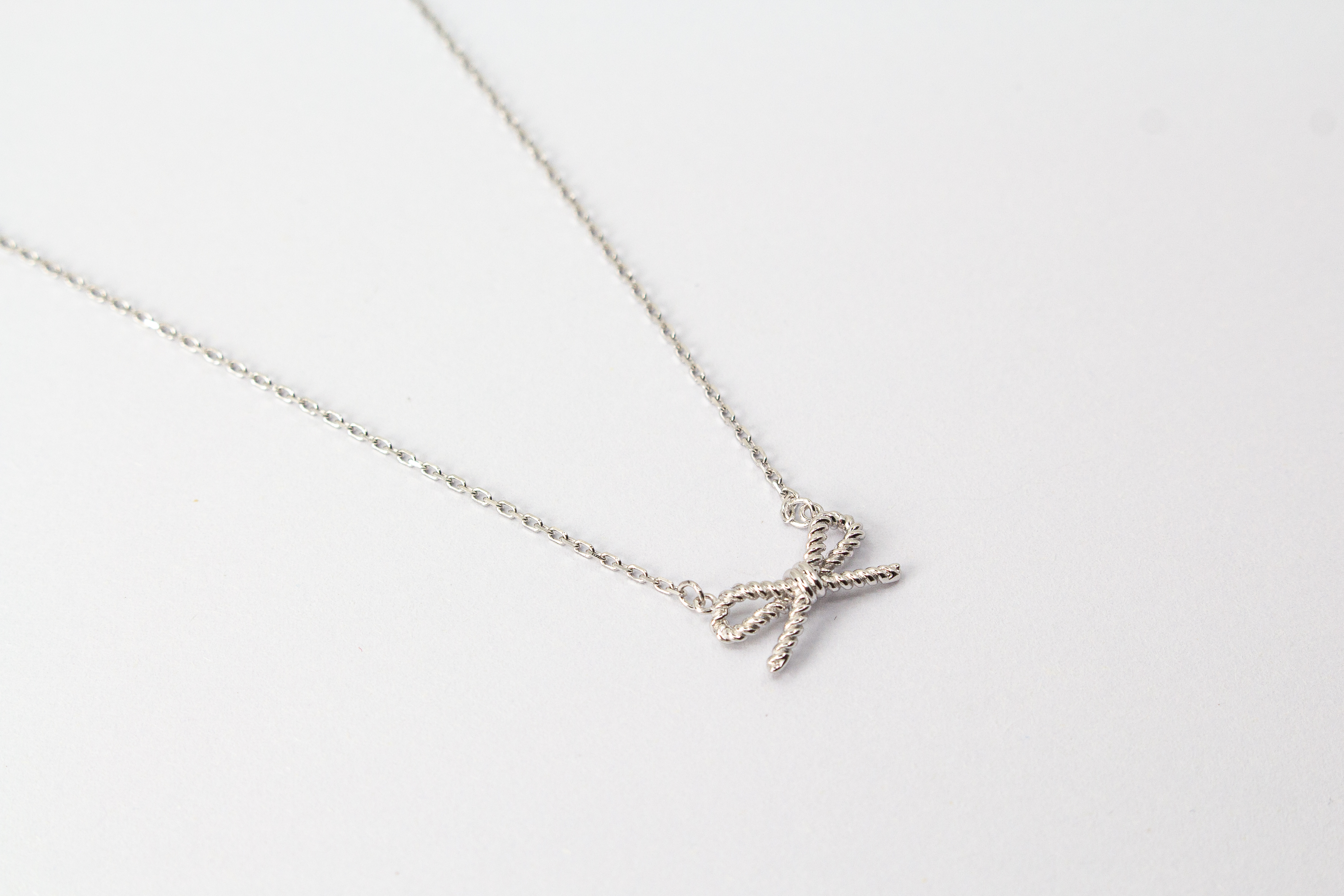 Collier „Schleifenzauber“ aus rhodiniertem 925er Sterlingsilber mit filigranem Schleifenanhänger in zeitlosem Design.