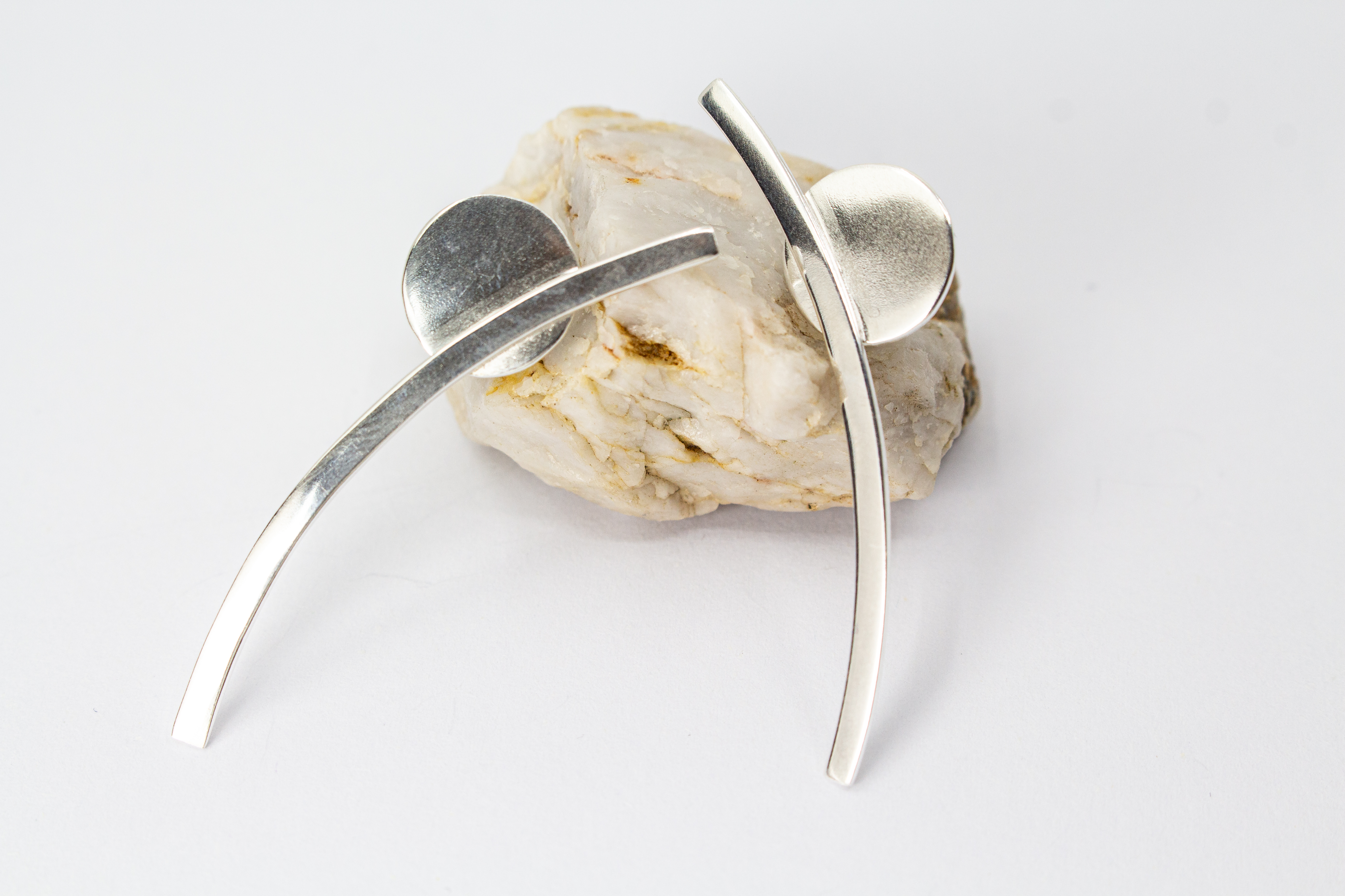 moderne, geometrische Ear Climber Ohrstecker aus glänzendem 925 Sterling Silber mit einer flachen Kreisscheibe und einem geschwungenen Silberstab aus dem Online-Shop der Goldschmiede Regina Kraus.