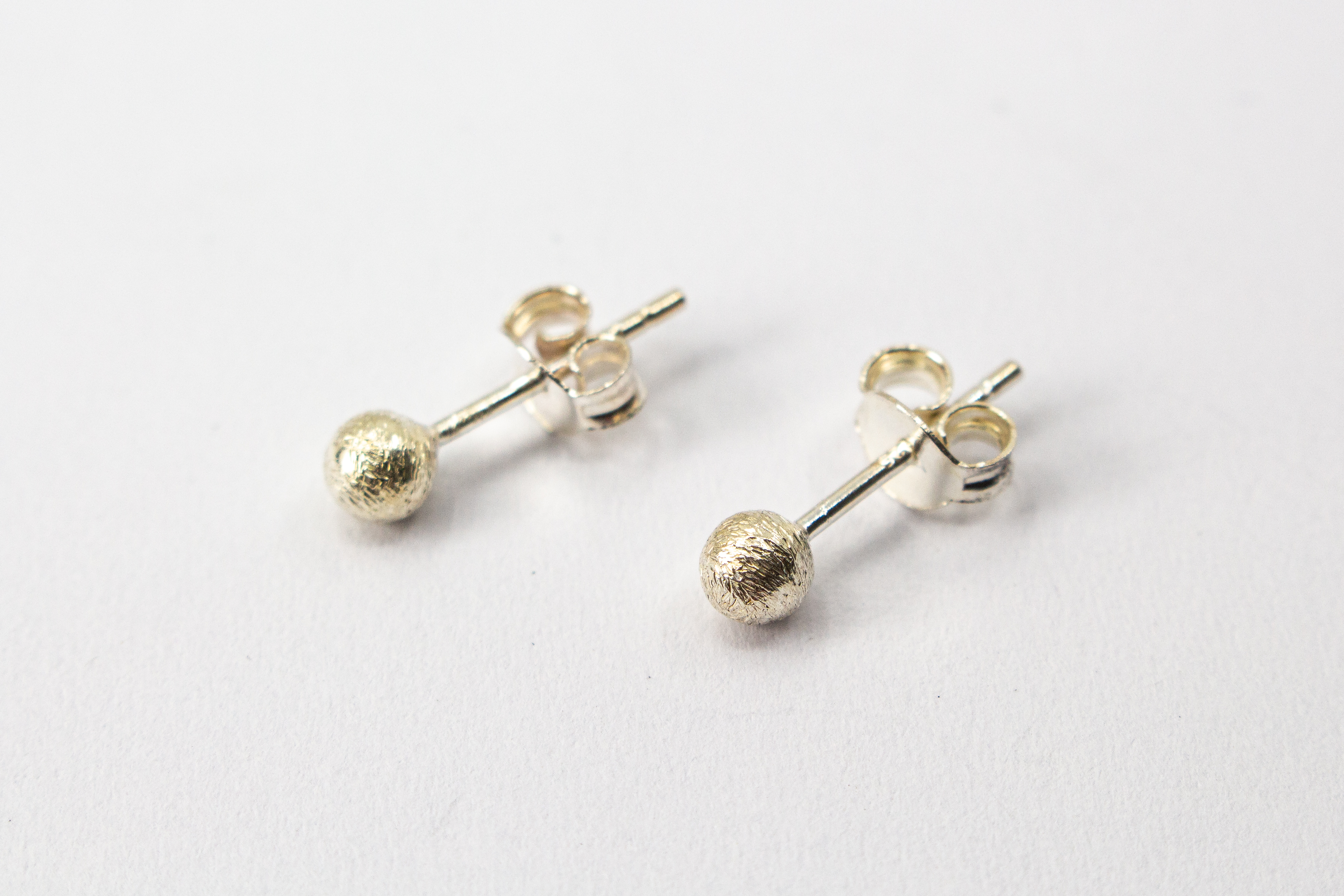 Klassische Kugel-Ohrstecker aus Silber mit mattierter, strukturierter Oberfläche im Onlineshop von Goldschmiede Regina Kraus.