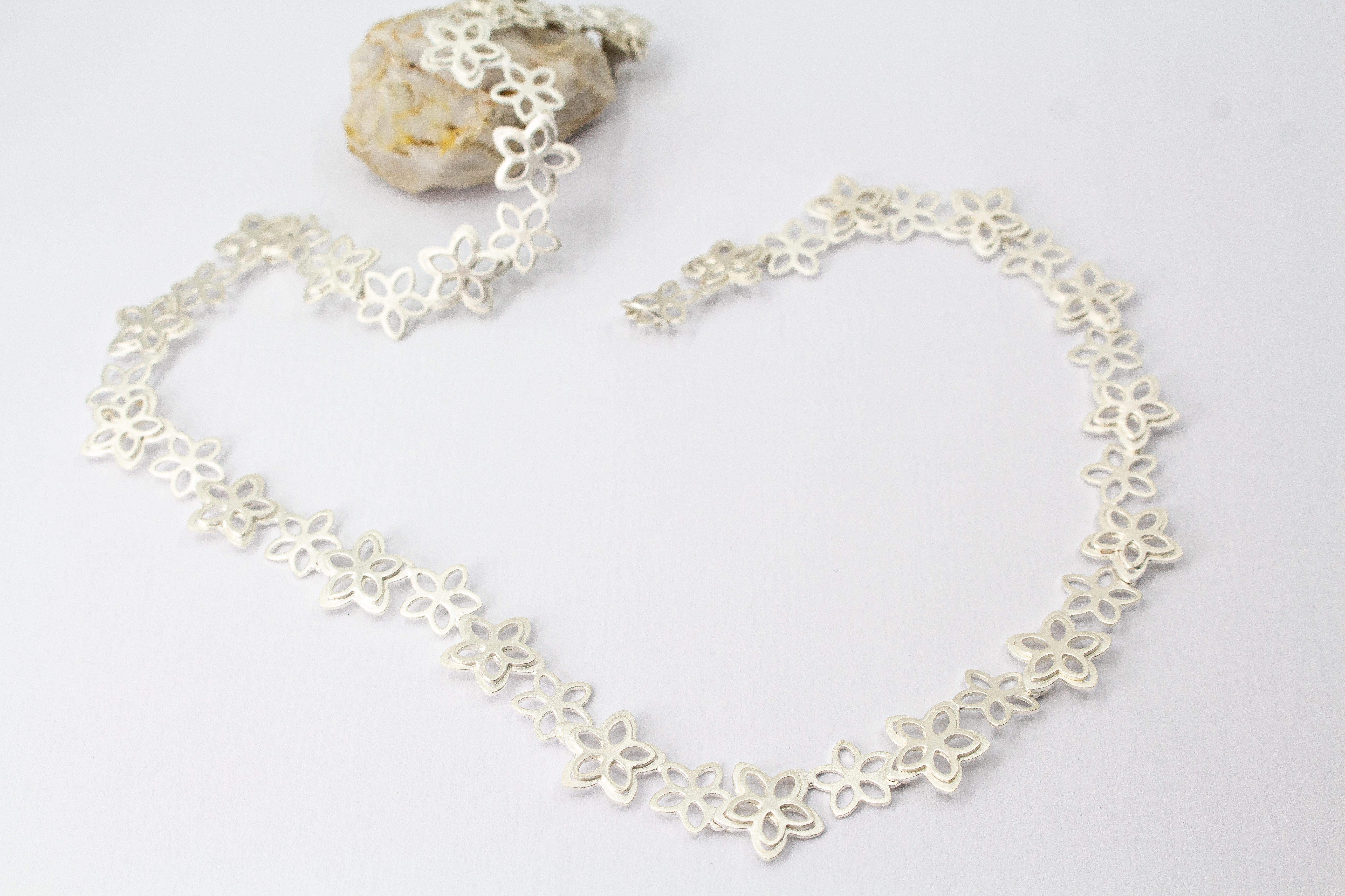 Filigranes Collier Rosalie aus der Goldschmiede Regina Kraus, gefertigt aus mattiertem 925er Sterling Silber mit aneinandergereihten, offenen Blüten-Motiven