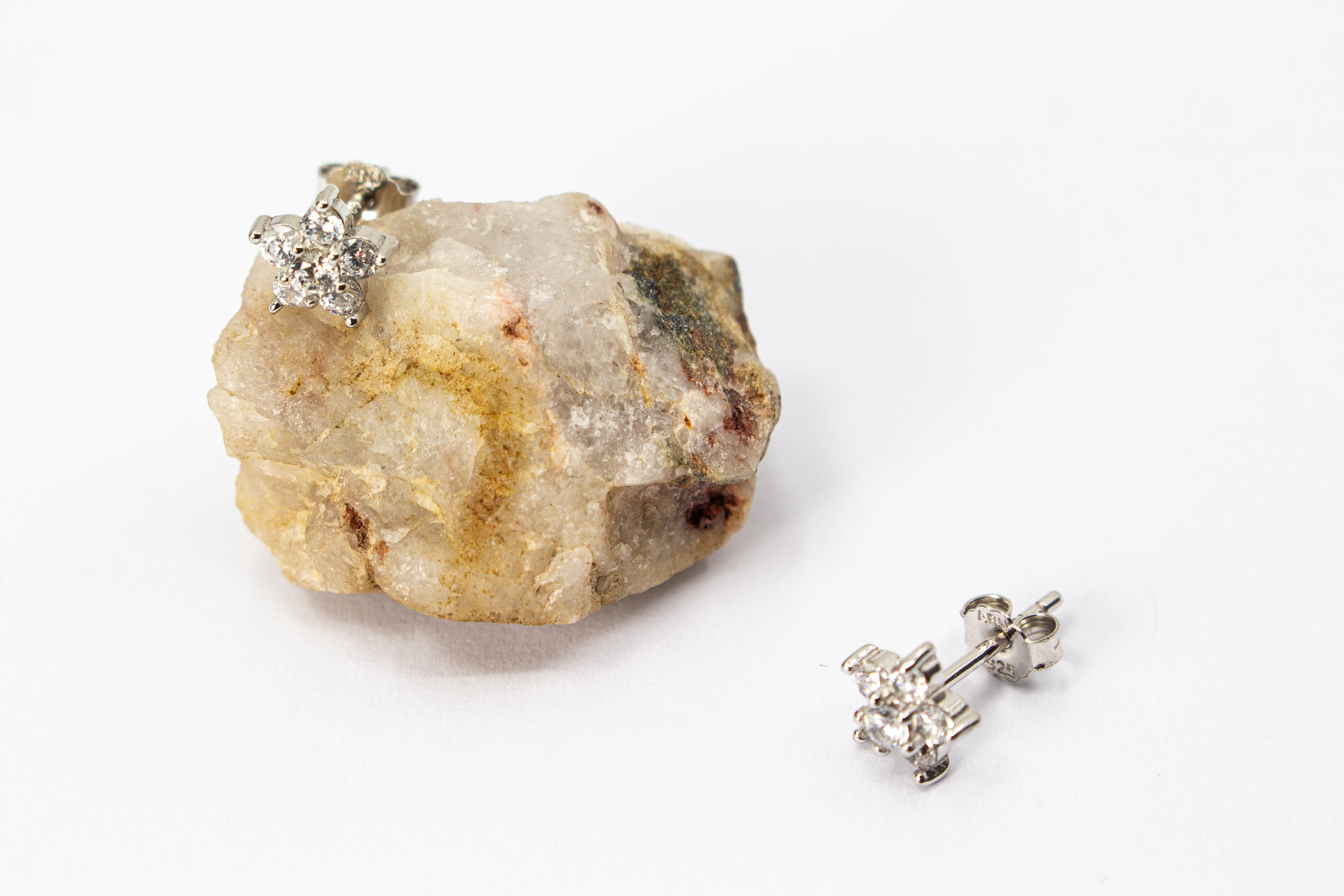 Filigrane Blumen-Ohrstecker aus rhodiniertem 925er Silber in Form einer kleinen Blüte mit funkelndem Zirkonia-Besatz im Onlineshop von Goldschmiede Regina Kraus.