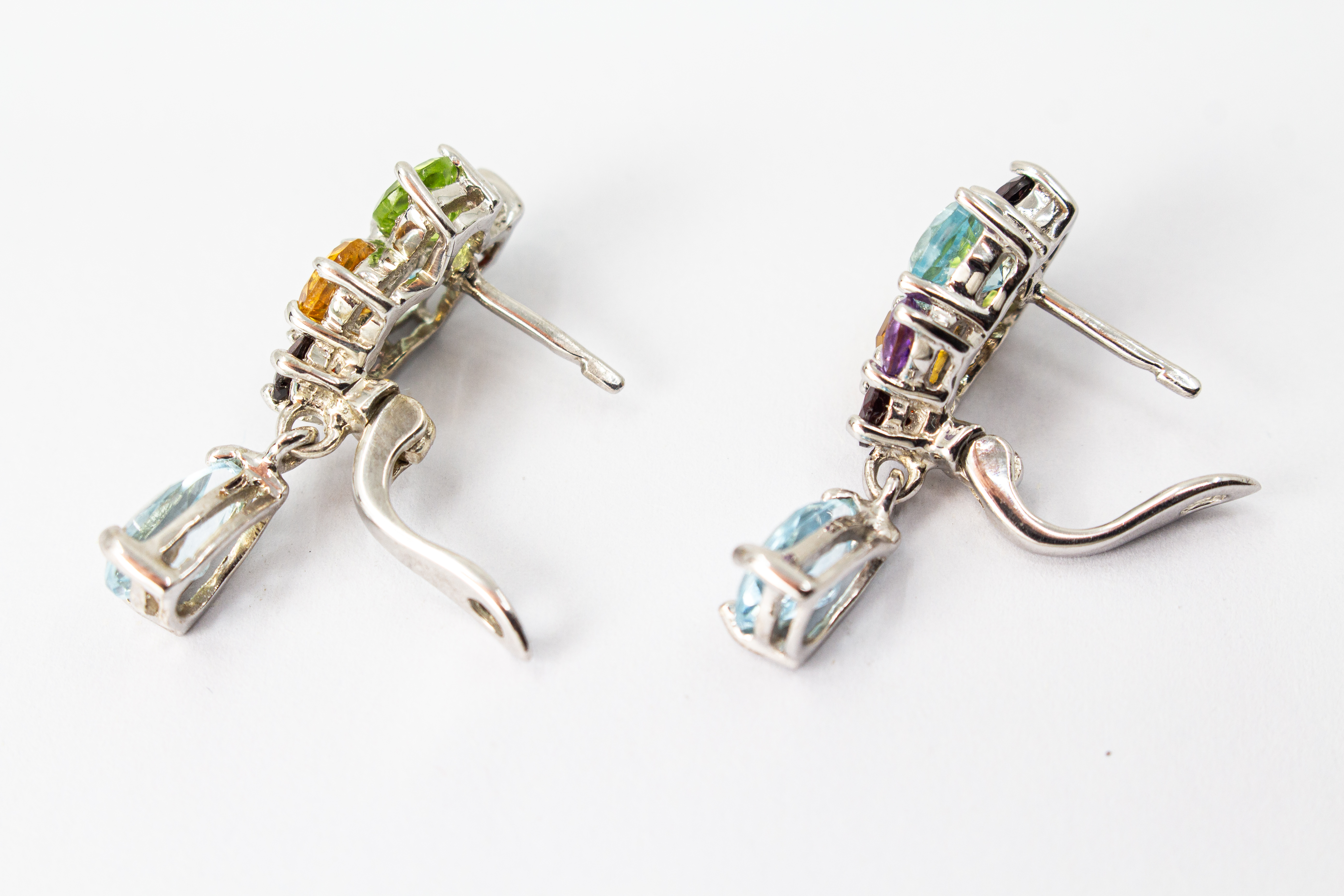 Elegante Multicolor-Edelstein-Ohrhänger aus rhodiniertem 925 Silber von der Goldschmiede Regina Kraus. Die detailreichen Ohrringe zeigen ein farbenfrohes Cluster aus rund facettierten Steinen wie Amethyst, Peridot, Citrin und Granat, gefolgt von einem bew