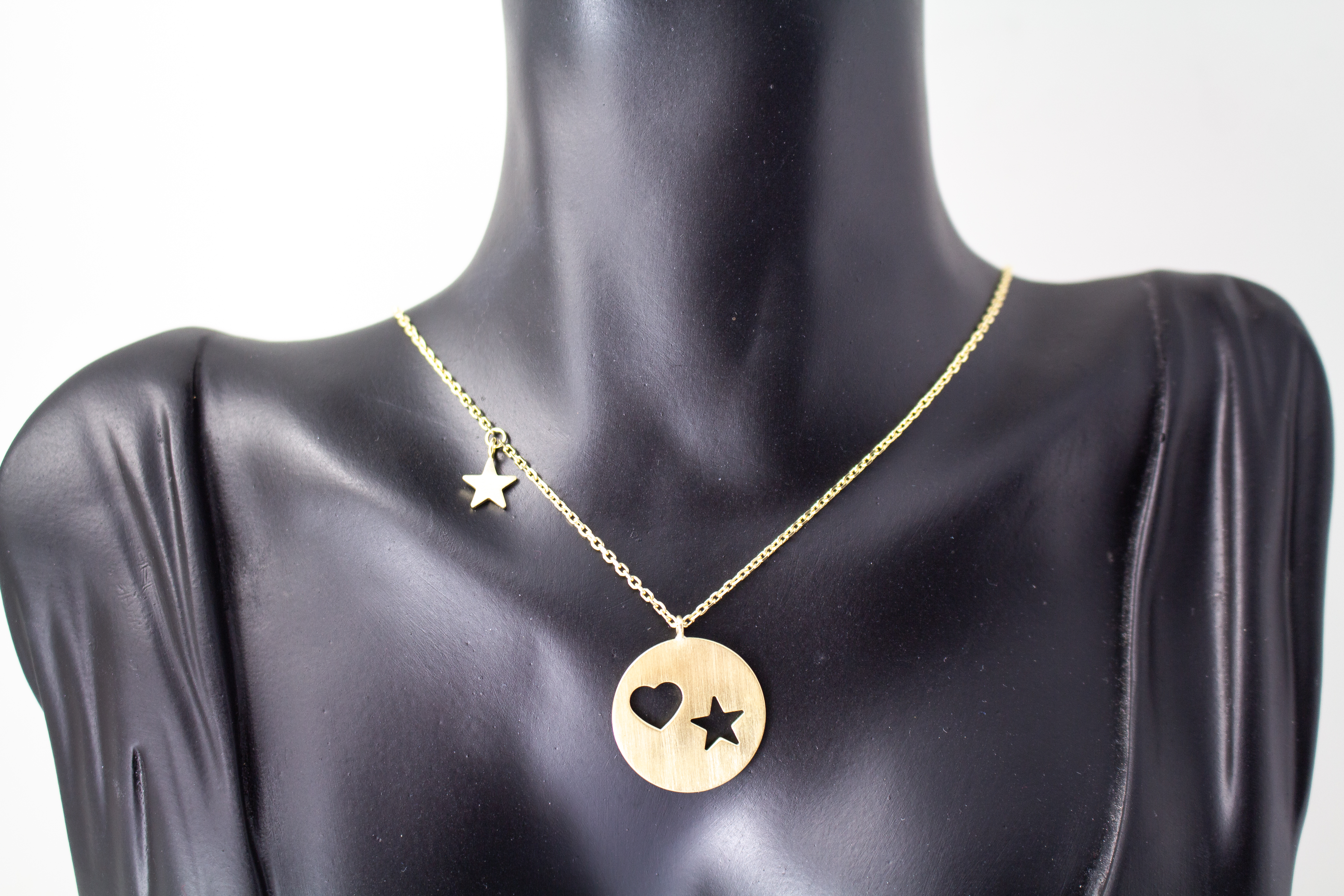 Collier „Sternenliebe“ aus vergoldetem 925er Sterlingsilber mit rundem Anhänger, Herz- und Sternmotiv sowie zusätzlichem Sternanhänger.