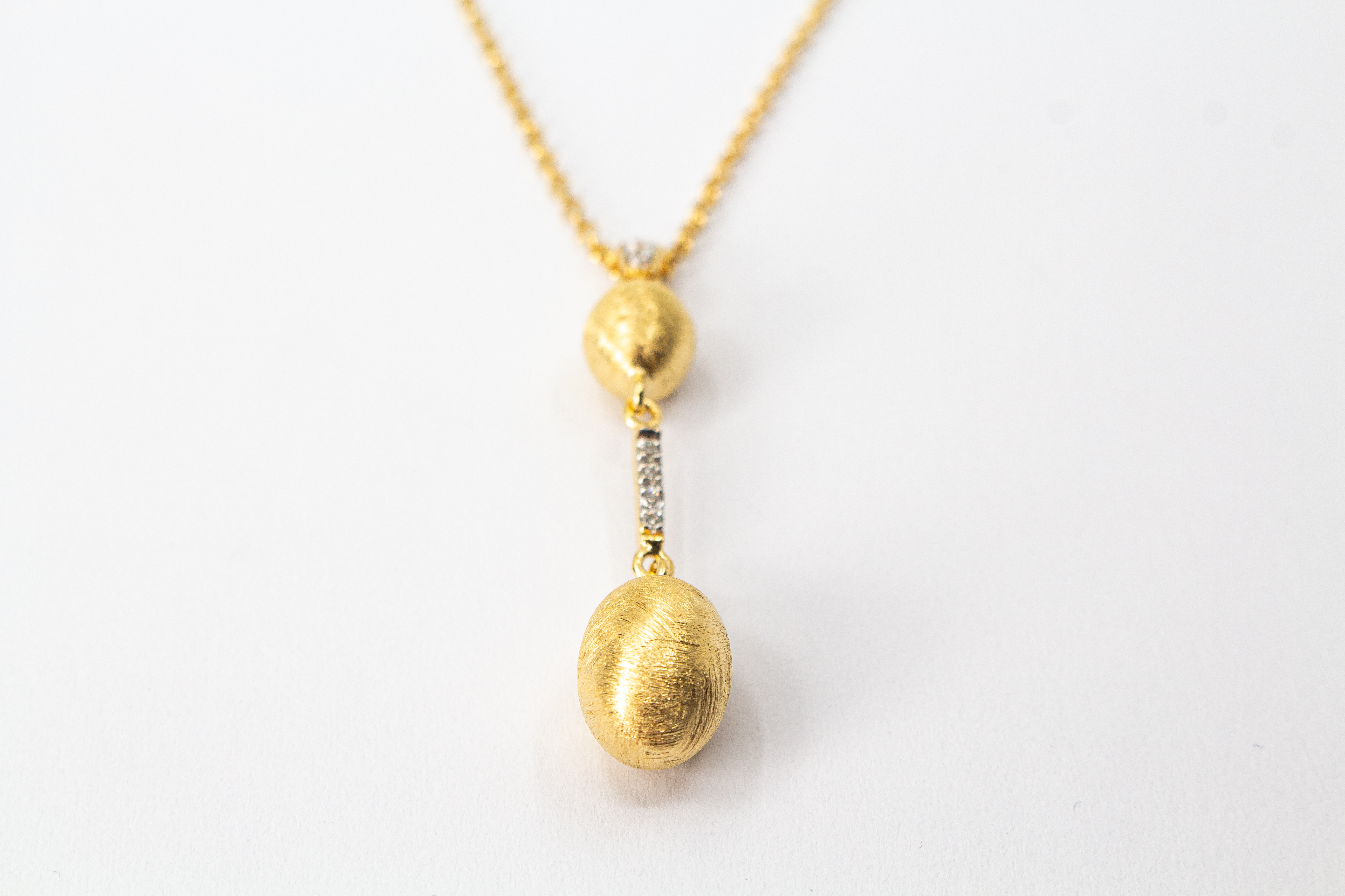 Elegante Halskette von Diva Gioielli aus vergoldetem 925 Silber mit zwei mattierten, ovalen Schmuckelementen, die durch einen mit funkelnden Zirkonia besetzten Steg verbunden sind.
