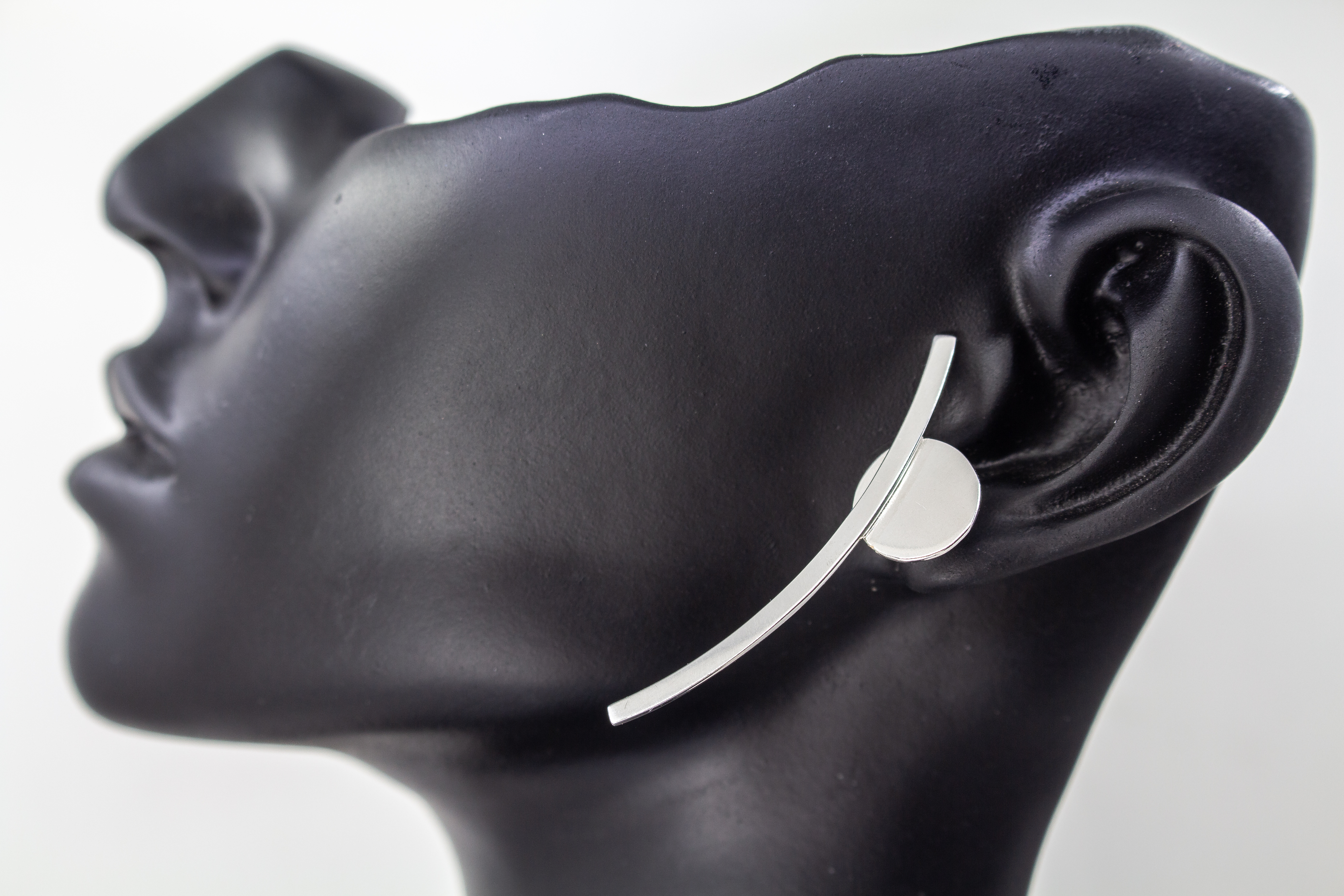 moderne, geometrische Ear Climber Ohrstecker aus glänzendem 925 Sterling Silber mit einer flachen Kreisscheibe und einem geschwungenen Silberstab aus dem Online-Shop der Goldschmiede Regina Kraus.