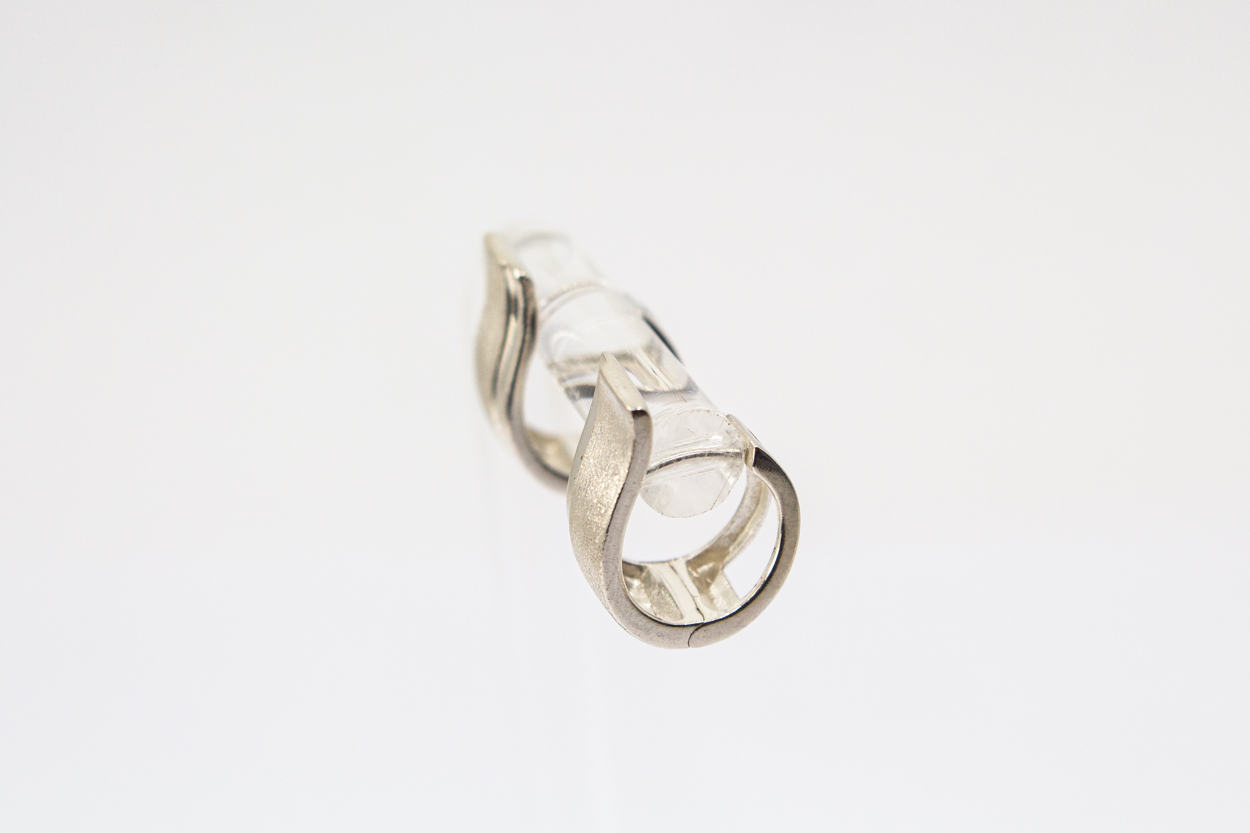 Breite Klappcreolen aus 925er Silber mit einer schwungvoll hochgezogenen, eismattierten Vorderseite und glänzend polierten Kanten im Onlineshop von Goldschmiede Regina Kraus.