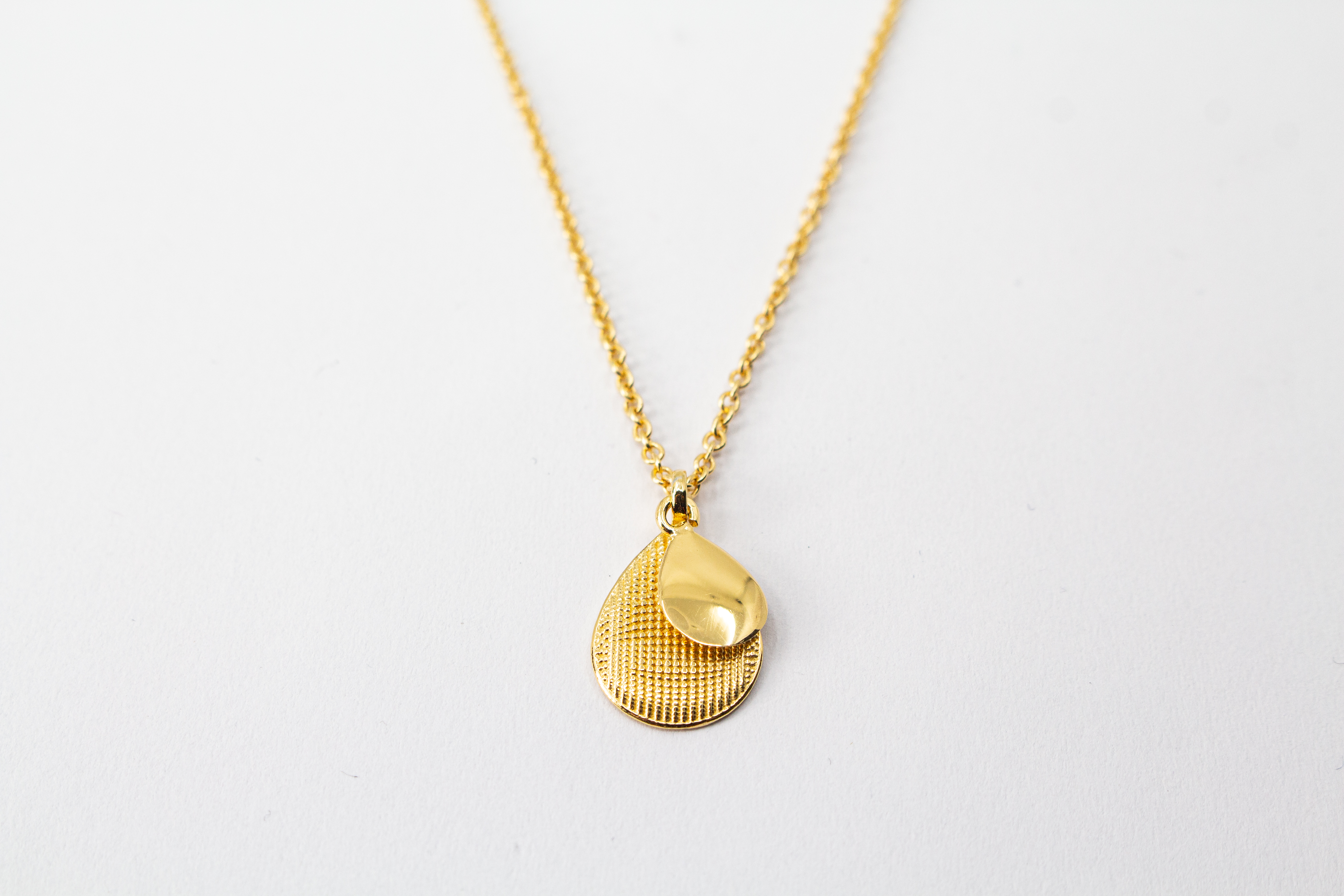 Italienische Design-Kette Cosmic Drop von Diva Gioielli: Anhänger aus zwei Tropfen in glänzendem und strukturiertem Gold-Finish, gefertigt aus vergoldetem 925er Sterlingsilber.