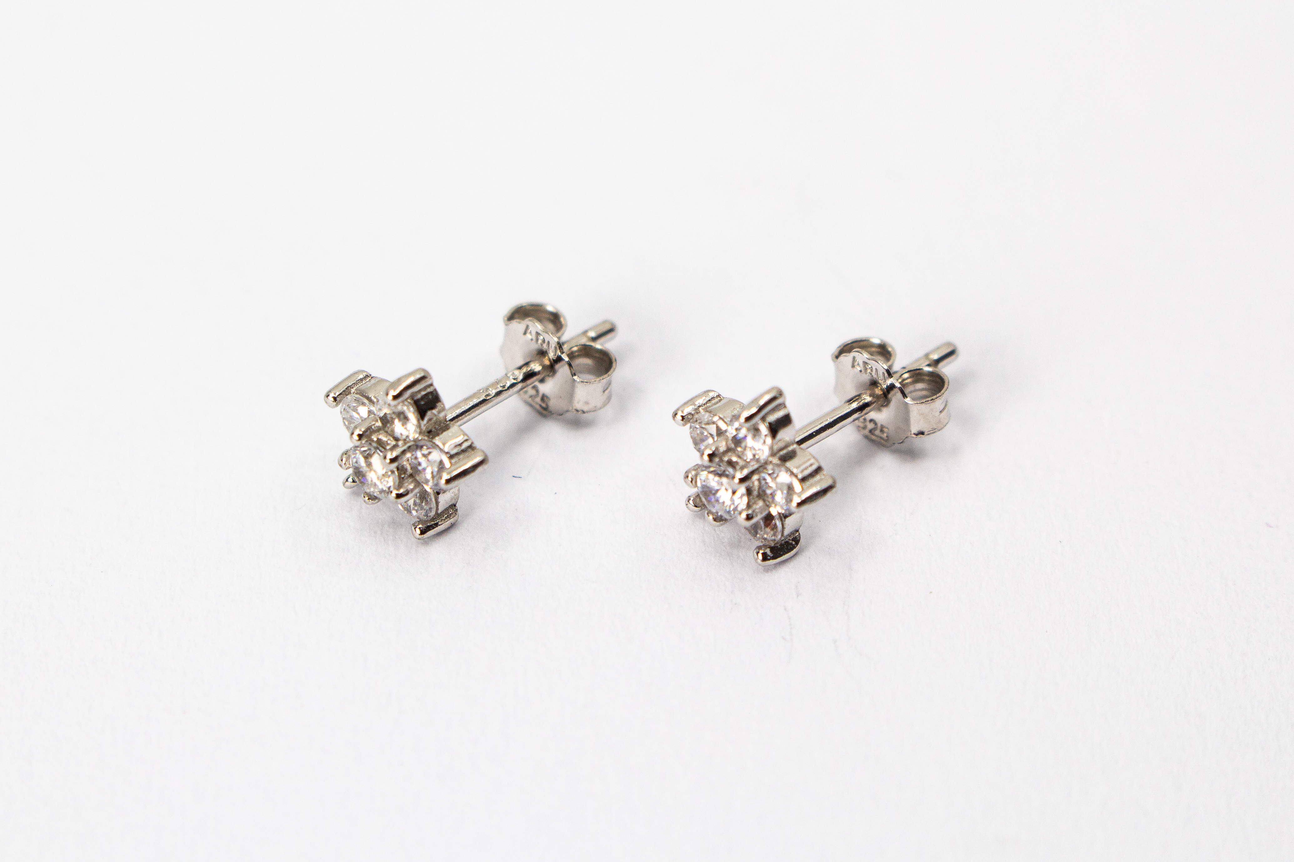 Filigrane Blumen-Ohrstecker aus rhodiniertem 925er Silber in Form einer kleinen Blüte mit funkelndem Zirkonia-Besatz im Onlineshop von Goldschmiede Regina Kraus.