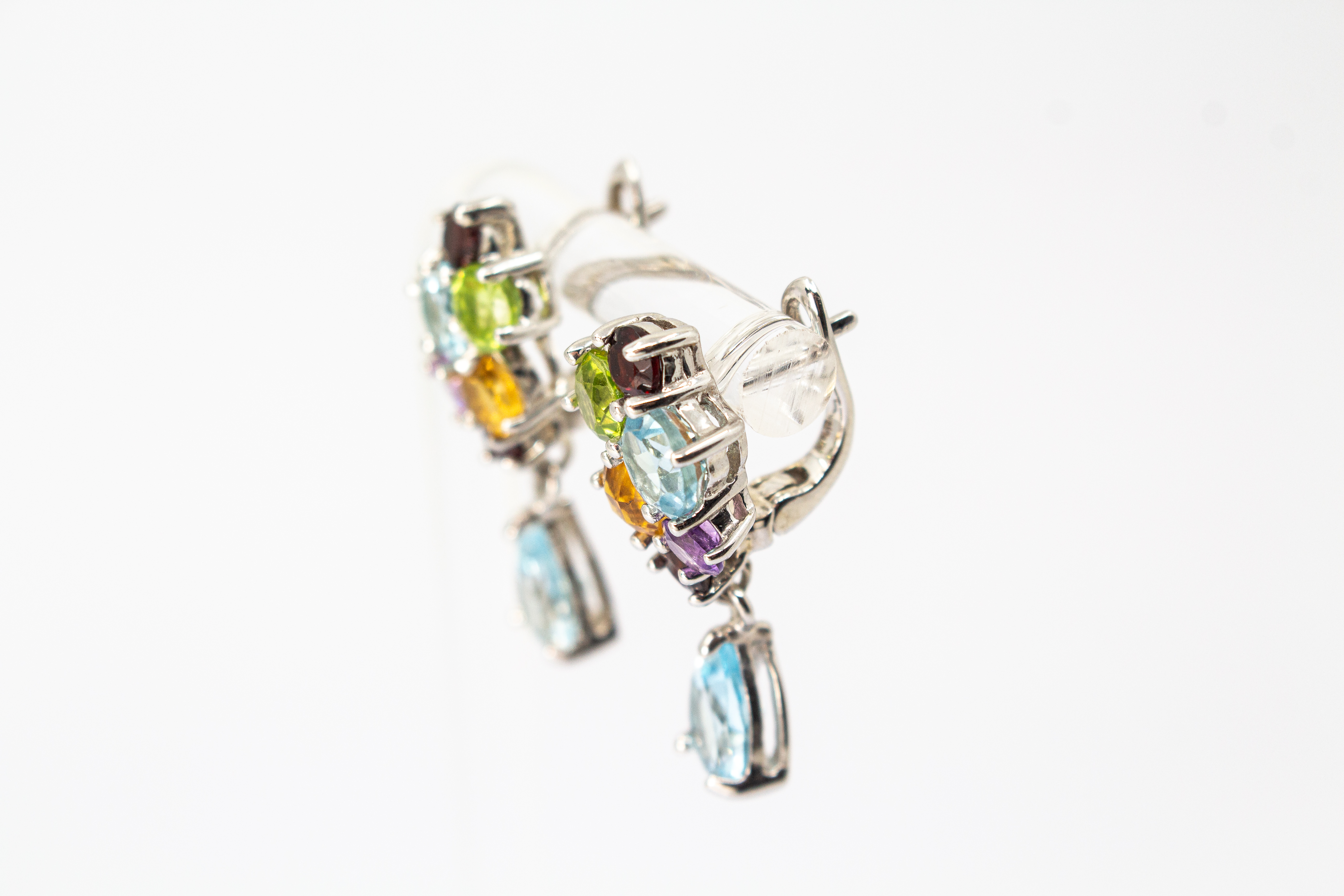 Elegante Multicolor-Edelstein-Ohrhänger aus rhodiniertem 925 Silber von der Goldschmiede Regina Kraus. Die detailreichen Ohrringe zeigen ein farbenfrohes Cluster aus rund facettierten Steinen wie Amethyst, Peridot, Citrin und Granat, gefolgt von einem bew