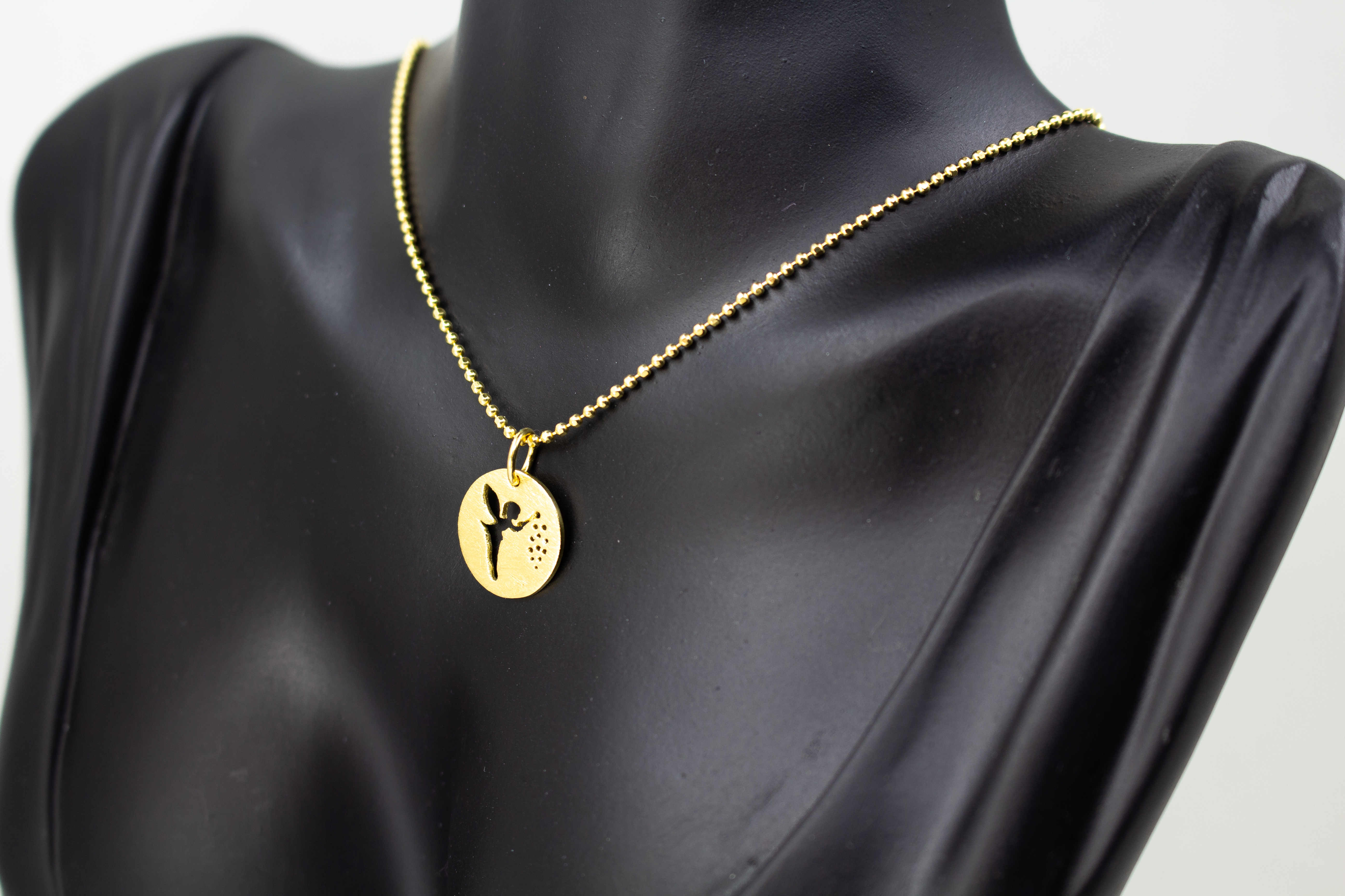 Goldene Kugelkette aus 20 Mikron vergoldetem 925er Sterlingsilber mit rundem Plättchen-Anhänger „Feenstaub“, der eine ausgestanzte Fee zeigt, aus dem Onlineshop der Goldschmiede Regina Kraus.