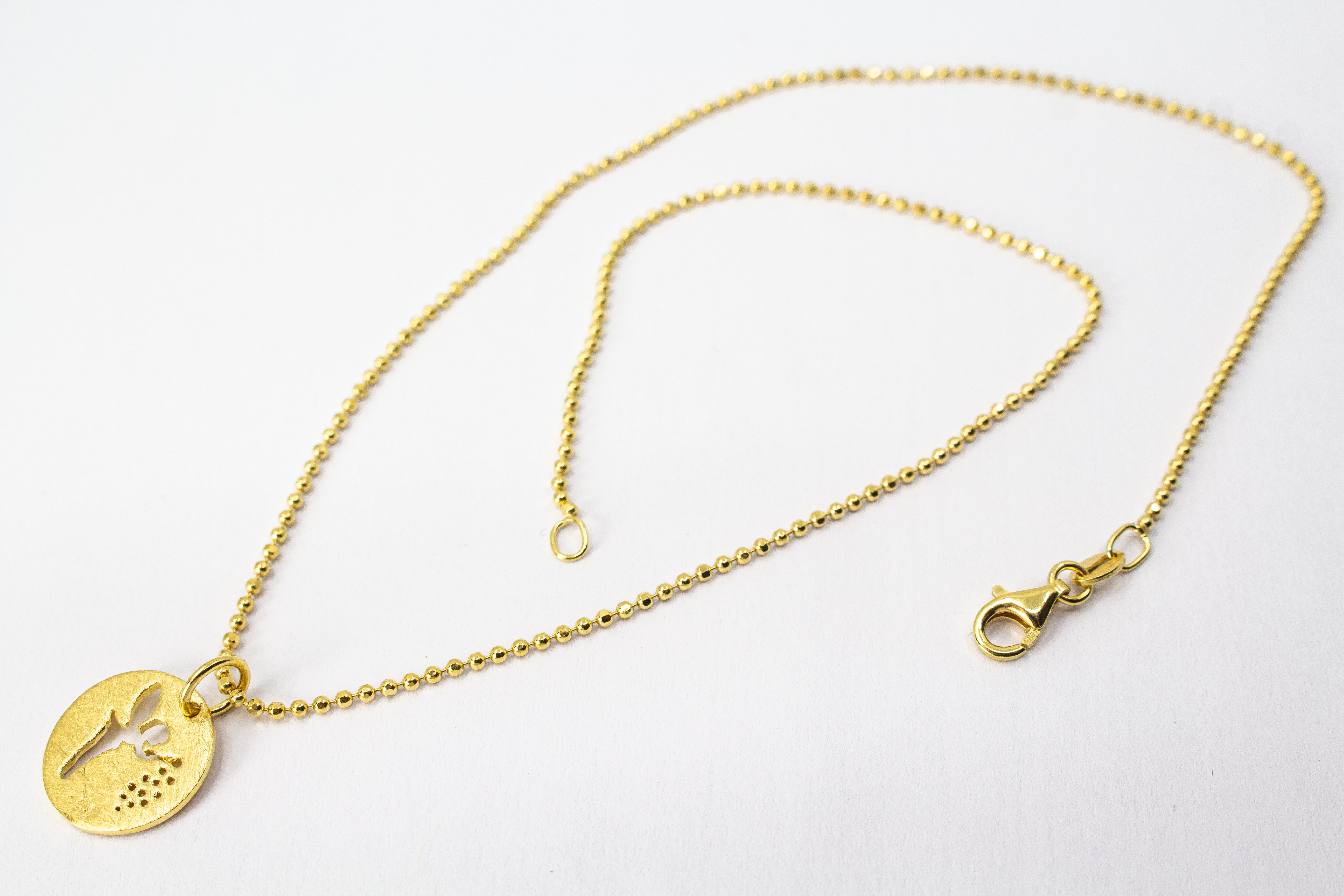 Goldene Kugelkette aus 20 Mikron vergoldetem 925er Sterlingsilber mit rundem Plättchen-Anhänger „Feenstaub“, der eine ausgestanzte Fee zeigt, aus dem Onlineshop der Goldschmiede Regina Kraus.