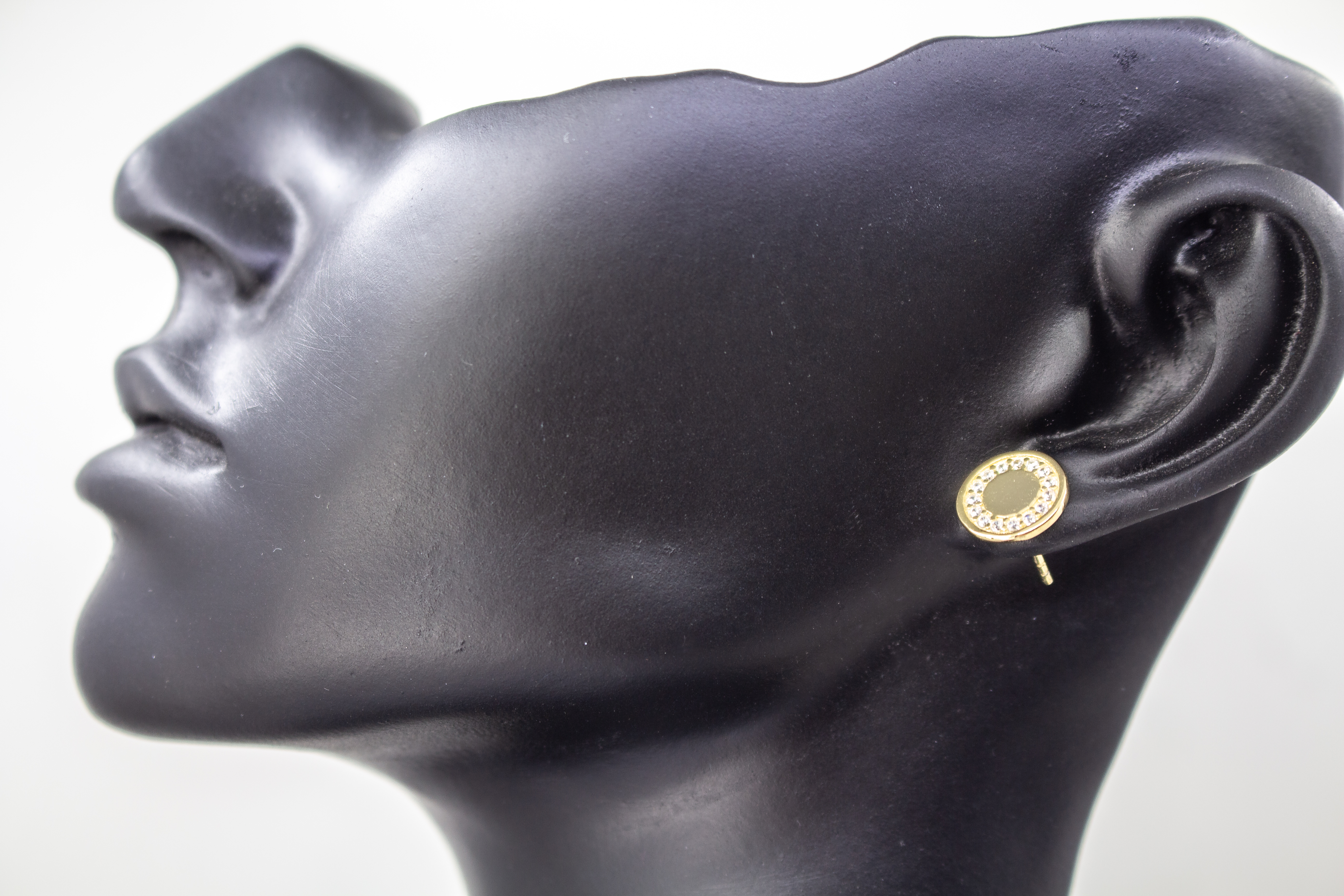 Runde, vergoldete Ohrstecker aus 925er Silber mit einer glatten Innenfläche und einem äußeren Kranz aus funkelnden Zirkoniasteinen im Onlineshop von Goldschmiede Regina Kraus.